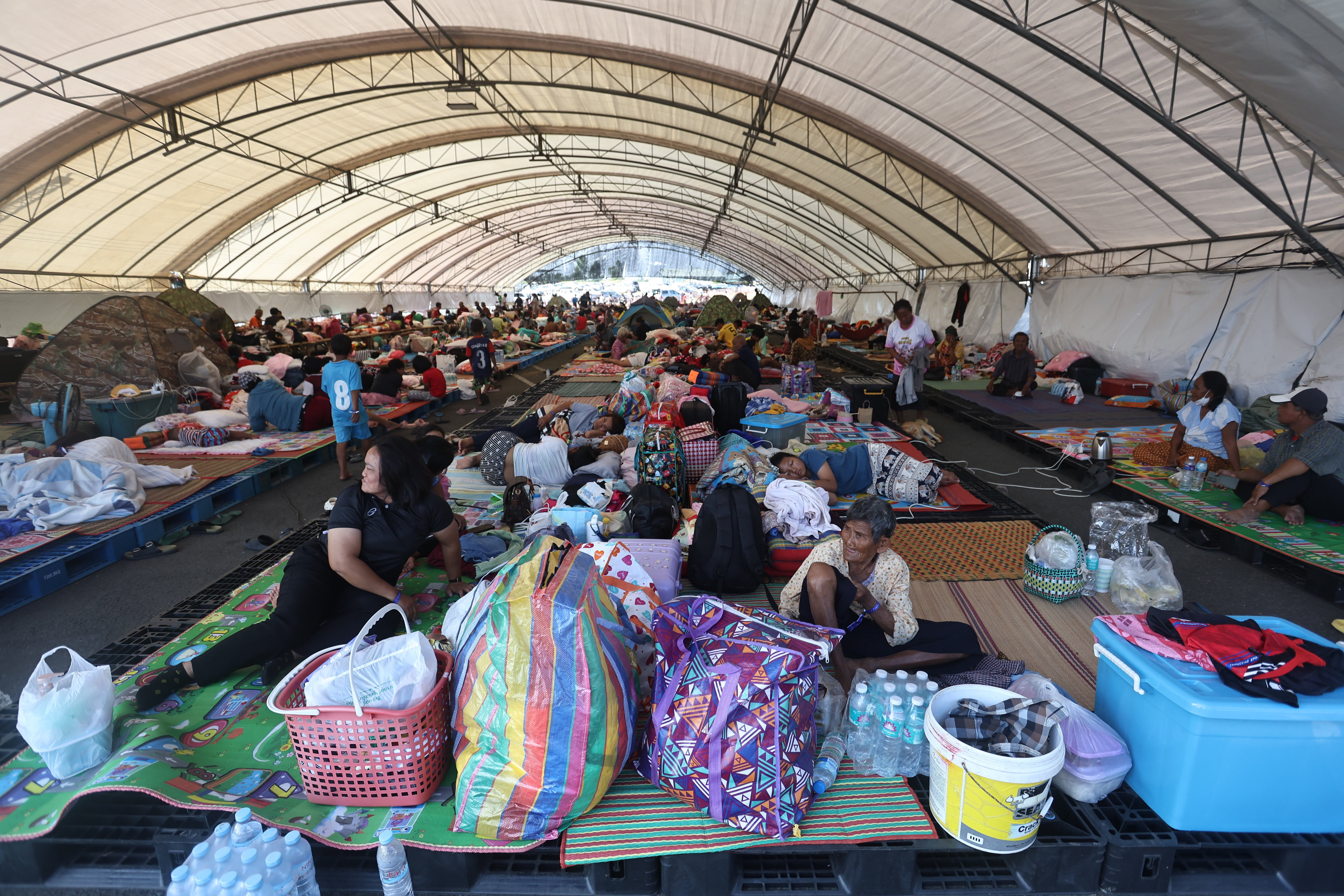 Thai residents who fled homes following clashes between Thai and Cambodian soldiers rest at an evacuation center in Buriram province, Thailand