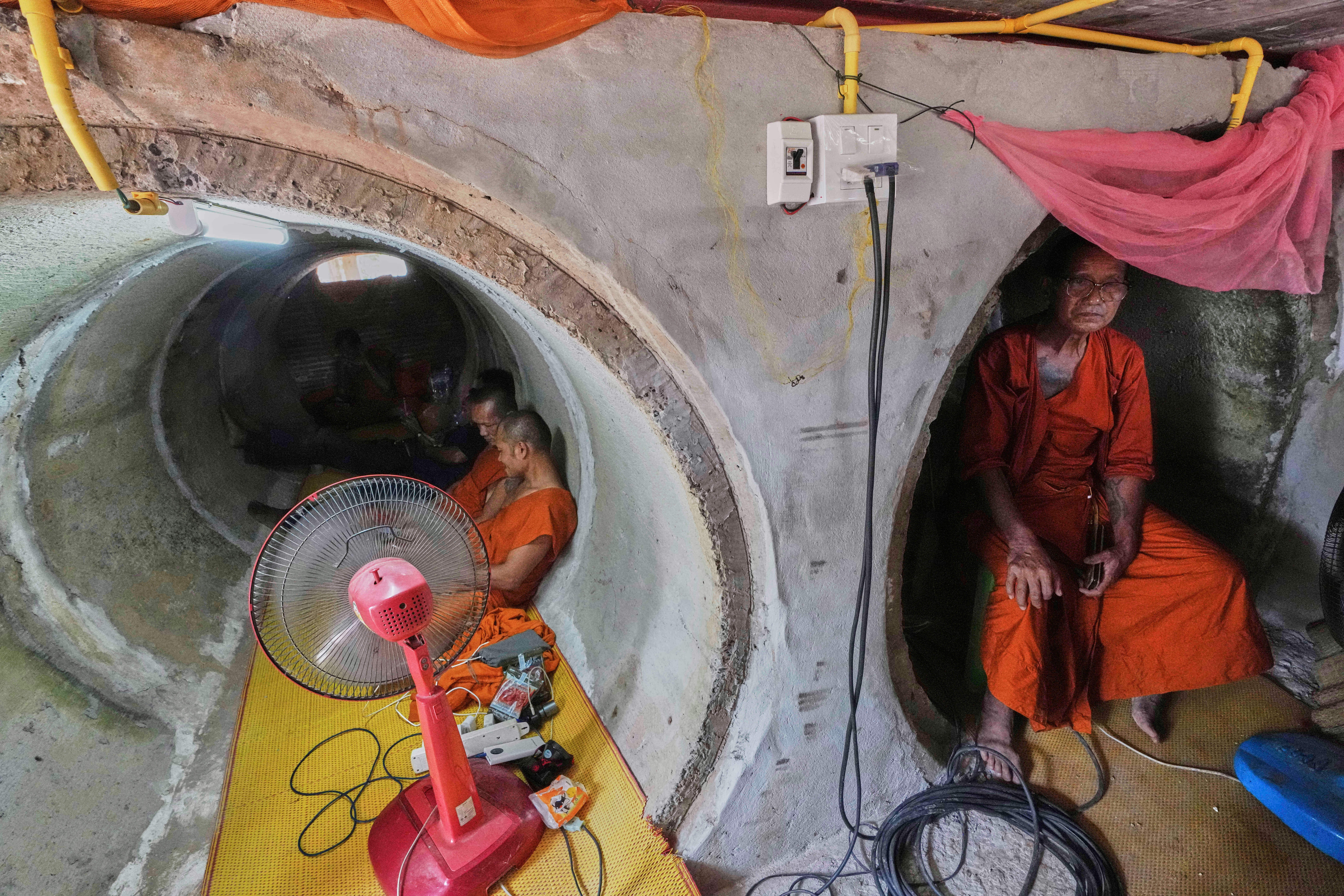 Abbot Phut Analayo, right, and other monks and residents who fled clashes between Thai and Cambodian soldiers, take shelter in Surin province, Thailand, 26 July 2025
