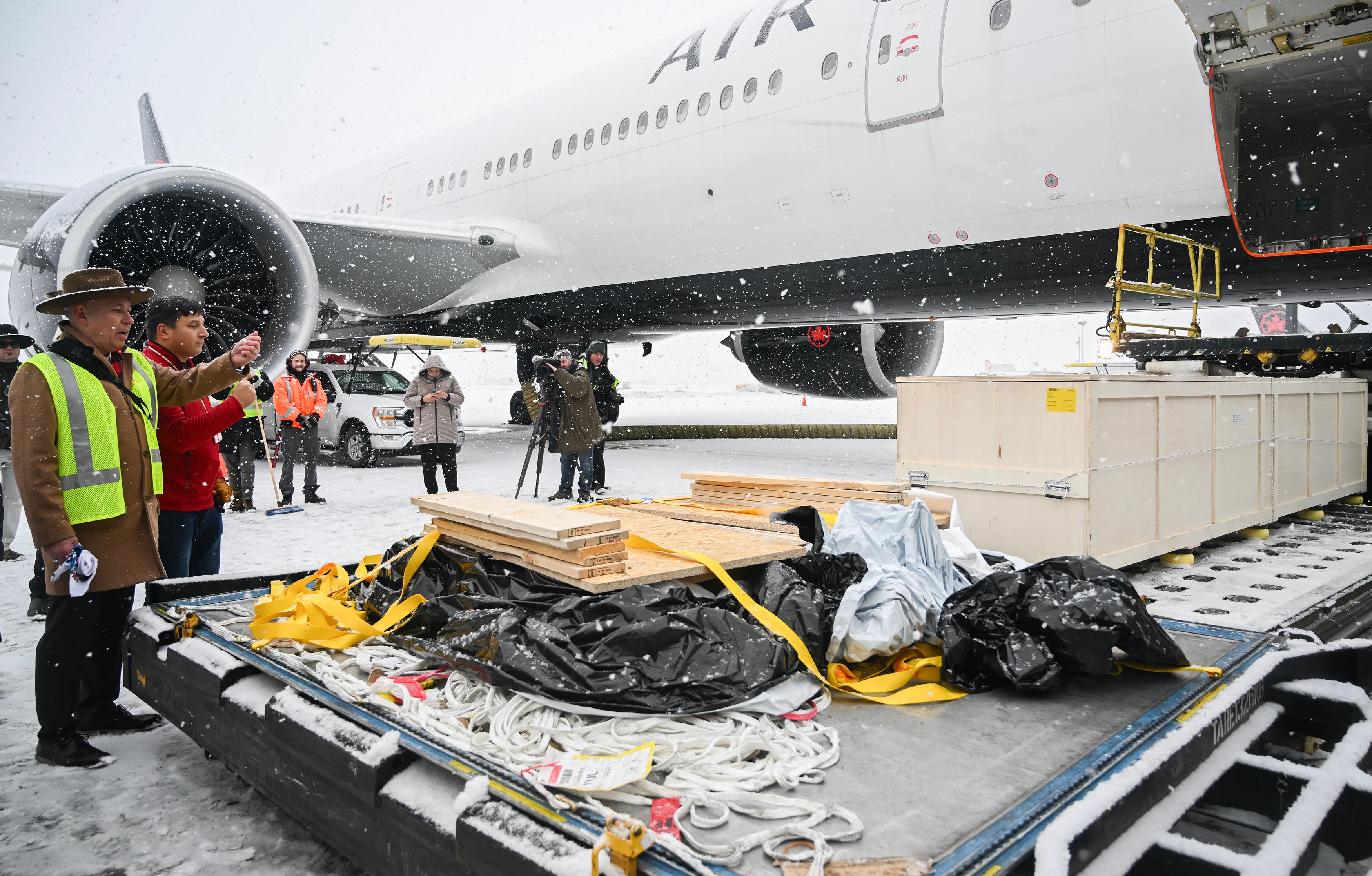 Representatives from various First Nations look on as a kayak and other indigenous artefacts arrive at Trudeau Airport in Montreal
