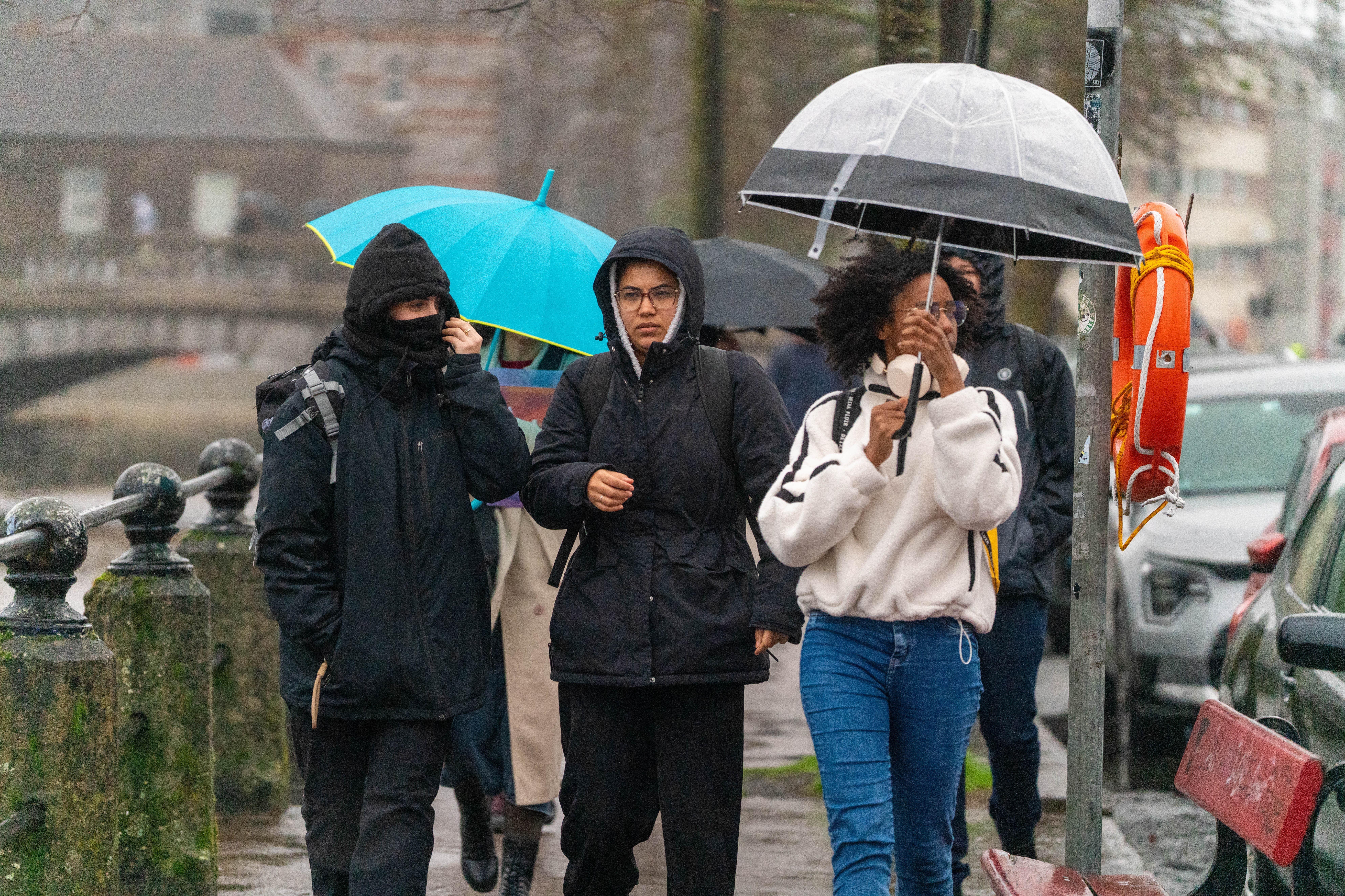 People shelter from the rain in Cork (Noel Sweeney/PA)