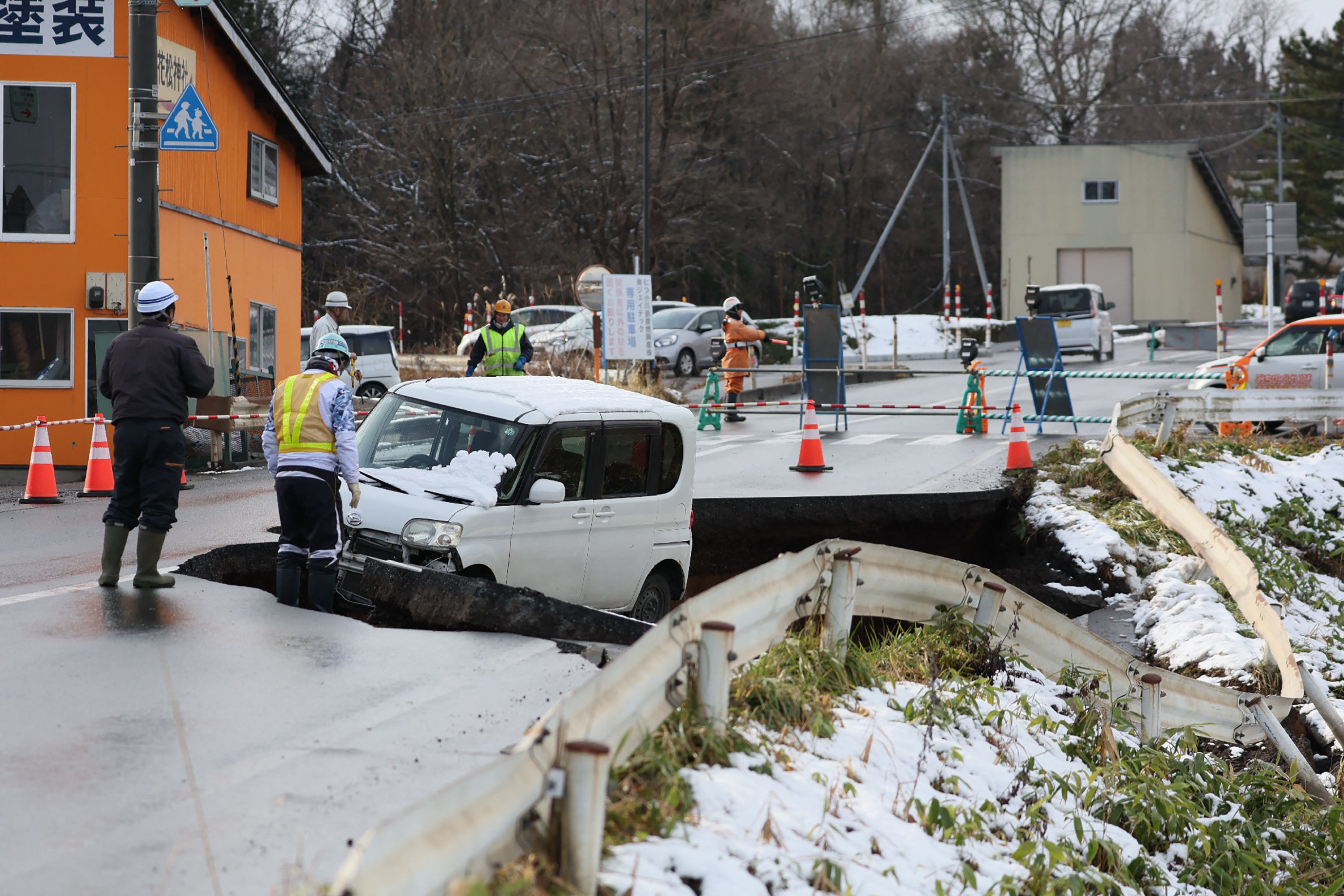 <p>A vehicle is seen on a collapsed road in Tohoku town in Aomori Prefecture on 9 December 2025, following a 7.5 magnitude earthquake off northern Japan </p>