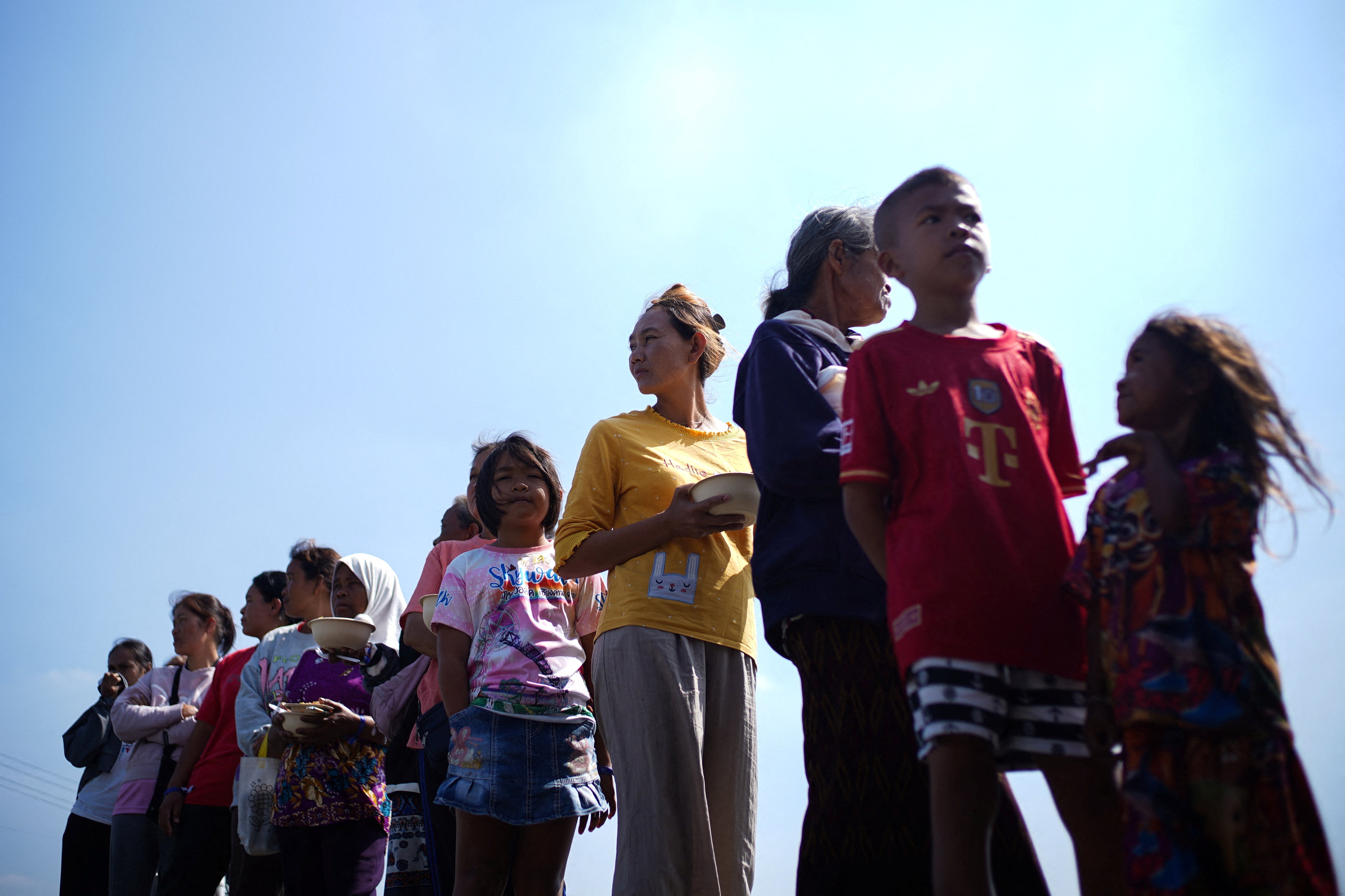 Displaced people queue for food at a temporary shelter amid deadly clashes between Thailand and Cambodia along a disputed border area, in Buriram province, Thailand, 9 December 2025