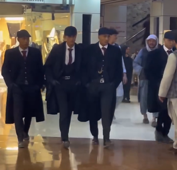 Four Afghan men, dressed as the Shelby Family, move around a complex in Afghanistan’s Herat