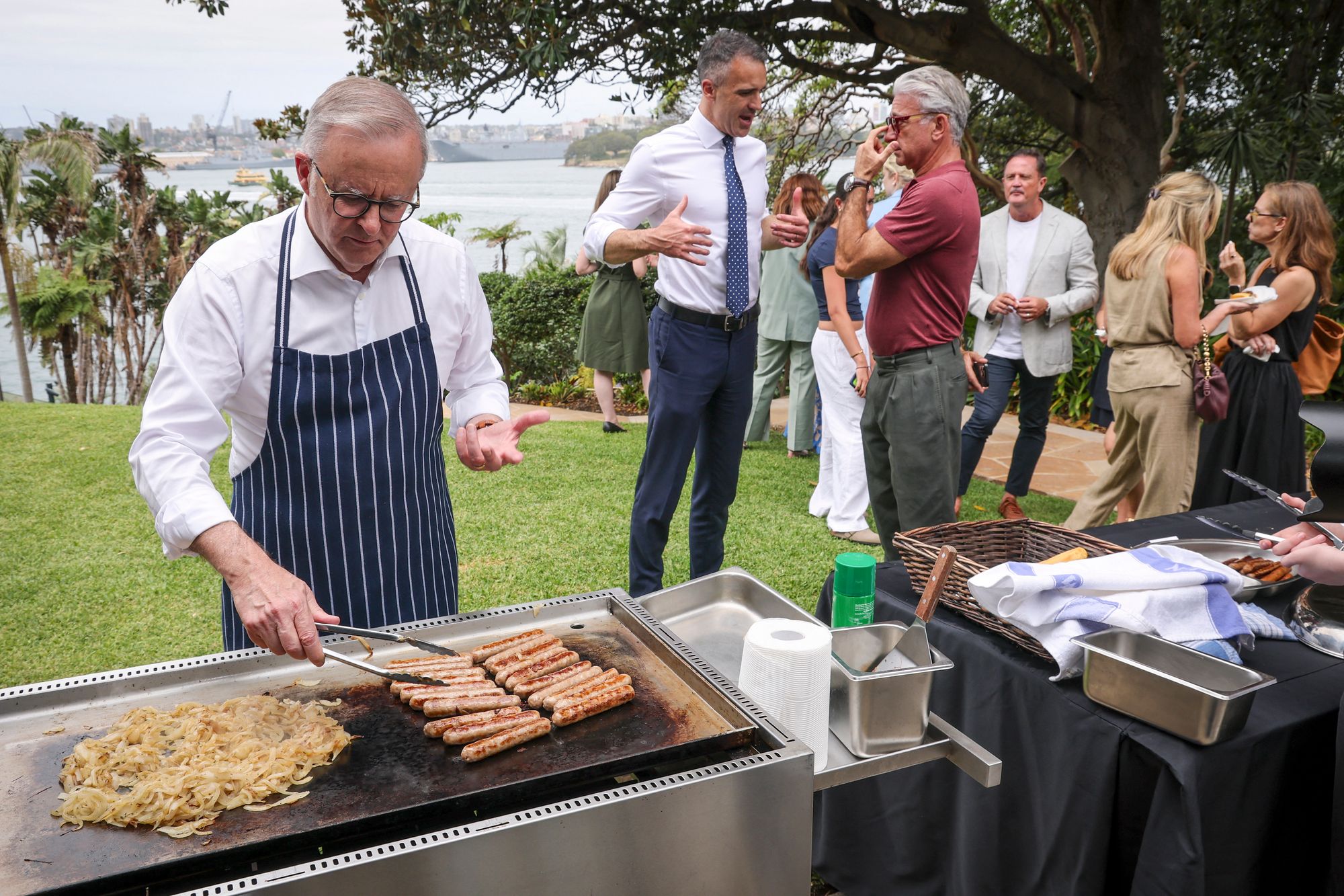 Albanese cooks sausages on a barbecue during an official function to mark the start of Australia's social media ban in Sydney on 10 December 2025