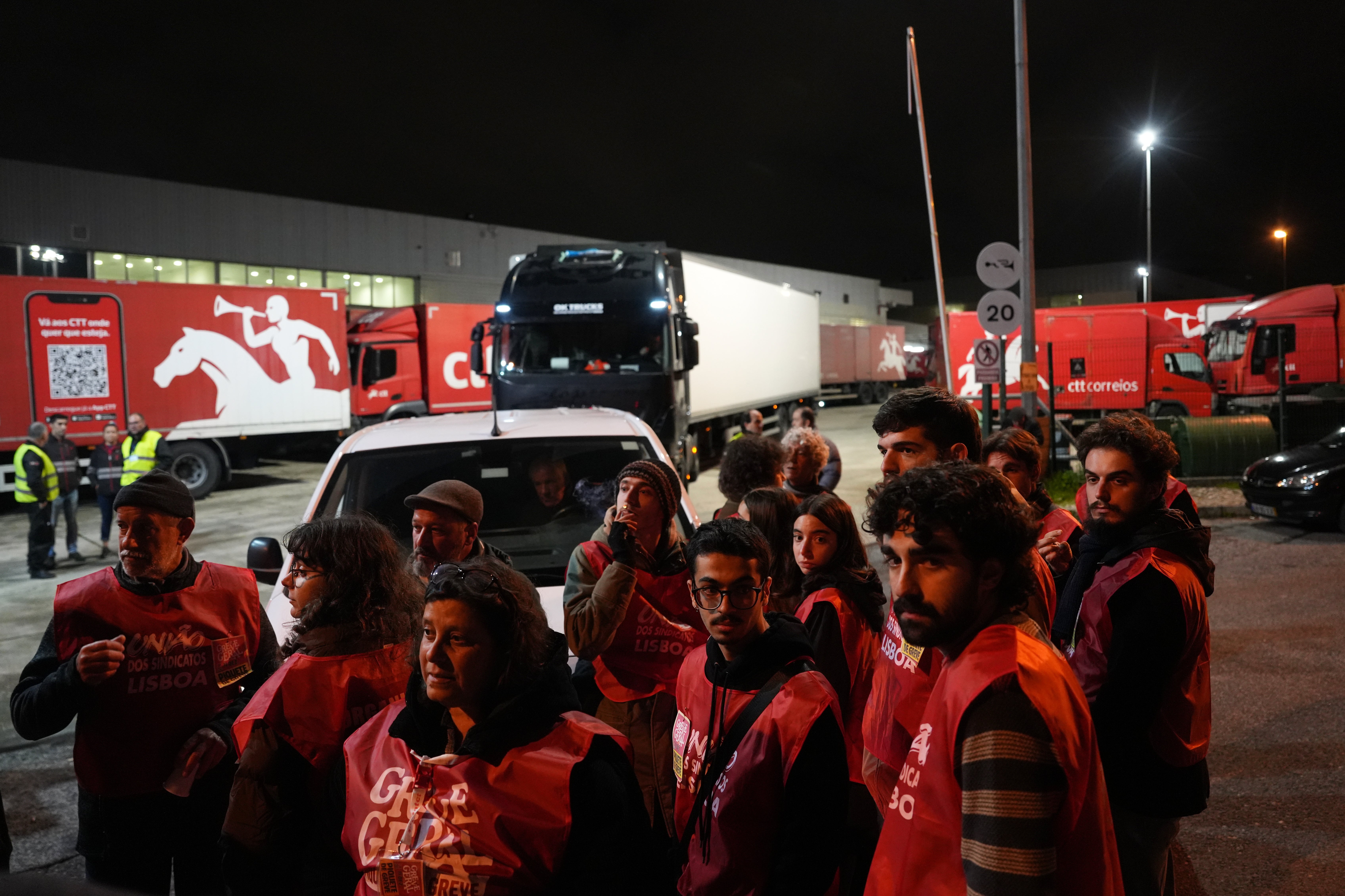 Striking workers block the entrance to warehouses of the Portuguese postal services company stopping trucks leaving.