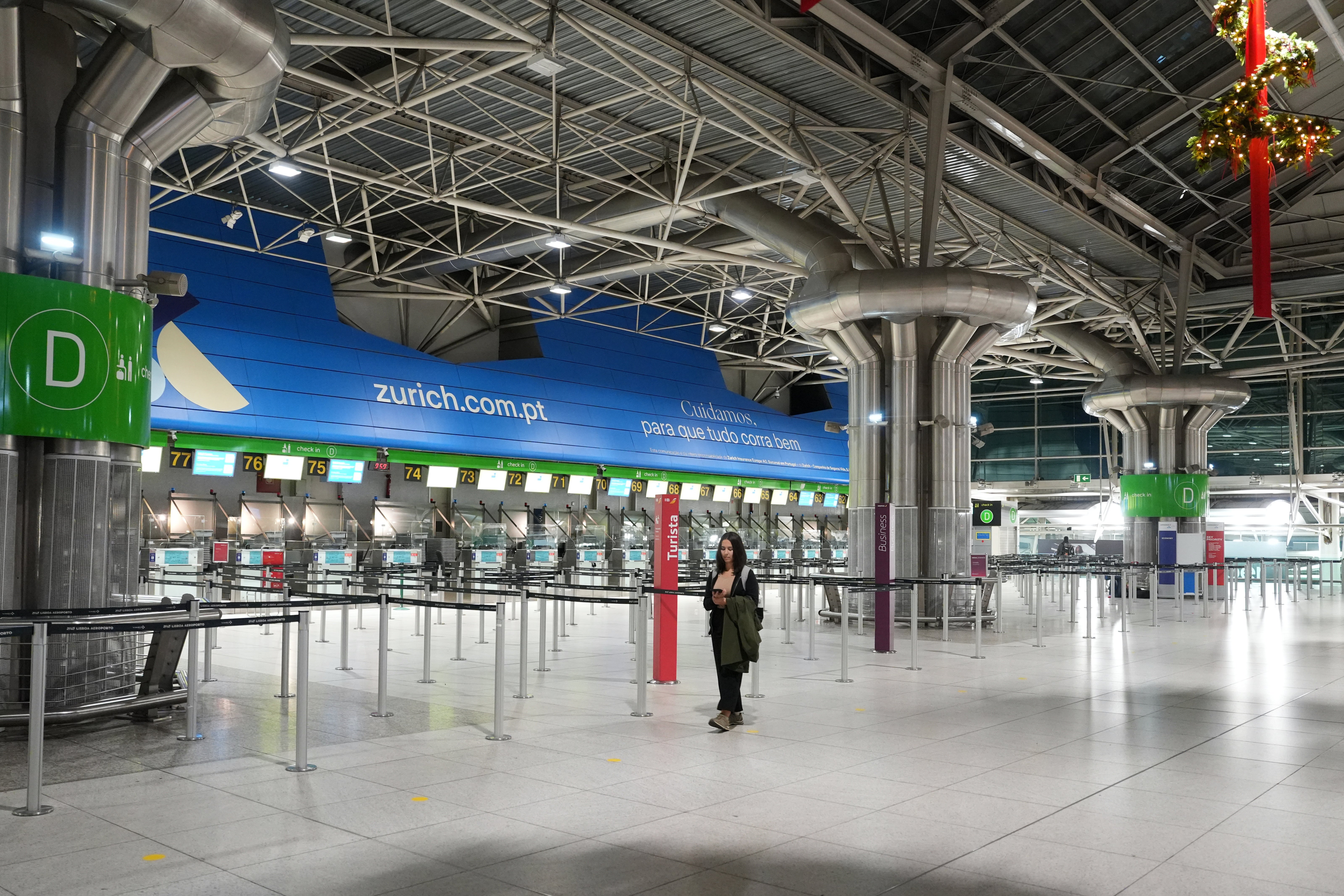 A woman walks through a nearly deserted hall of the Lisbon airport at the start of a general strike.