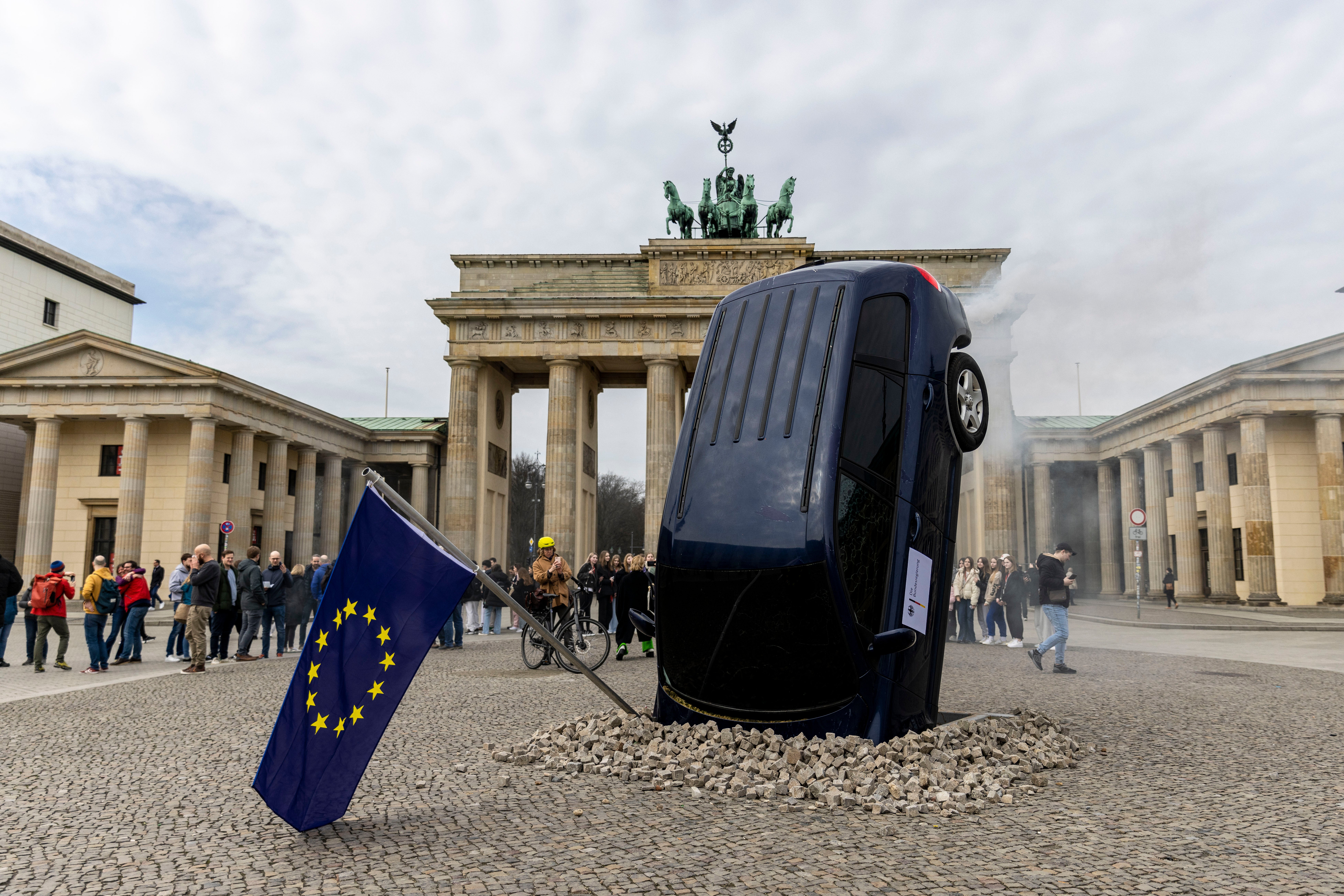 An installation by Greenpeace activists shows an SUV that is seemingly rammed into the pavement in front of the Brandenburg Gate on March 22, 2023 in Berlin, Germany