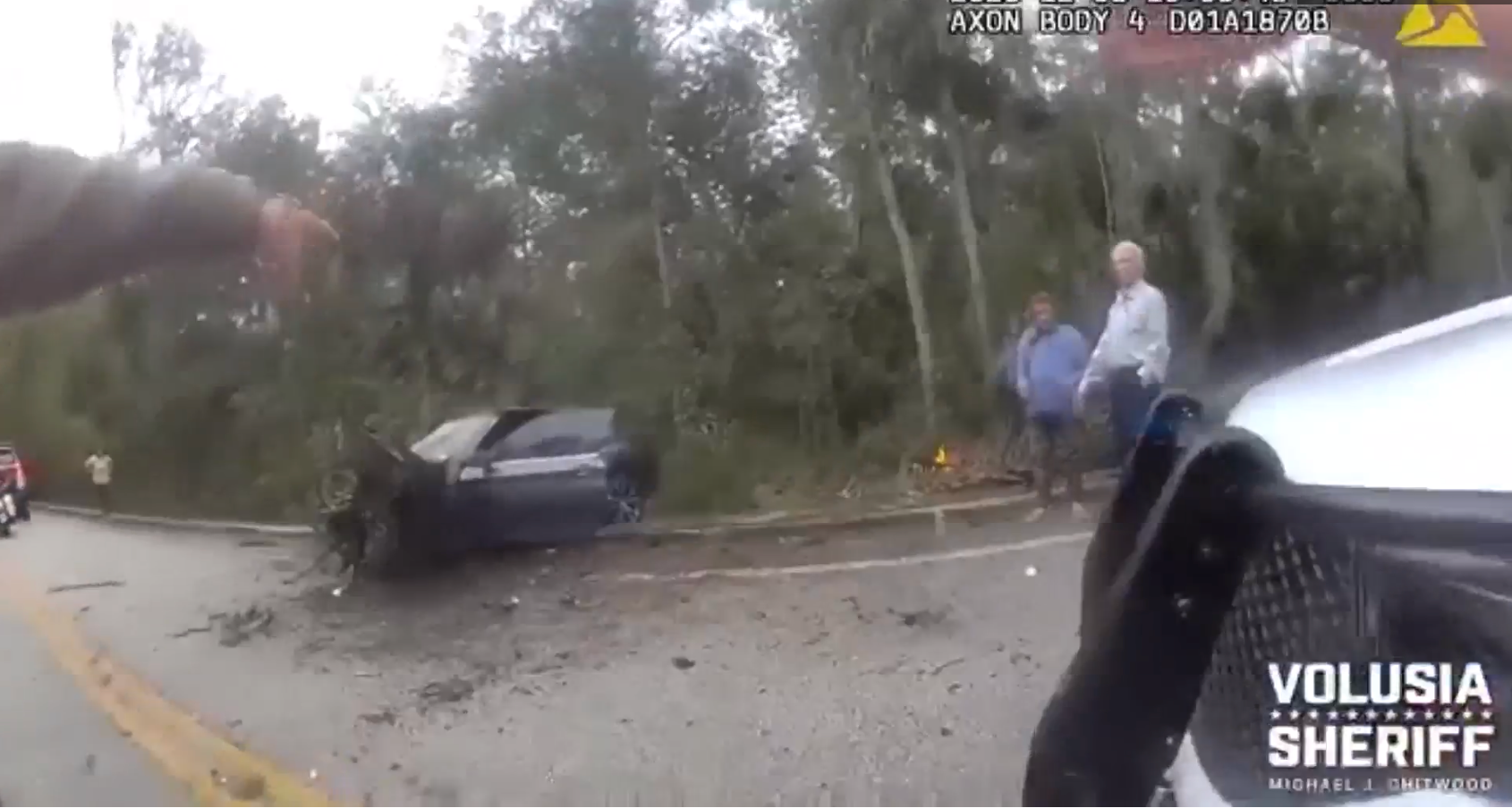 The crumbled up BMW with Calvin Curtis-Johnson beside the car