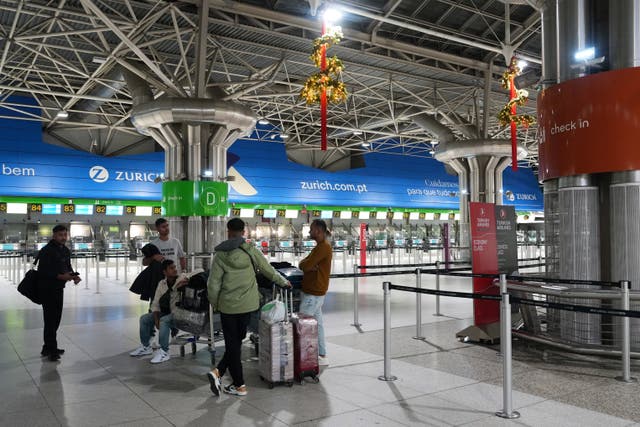 <p>A few passenger stand in a nearly deserted hall of the Lisbon airport at the start of a general strike to protest against a new labour package announced by the centre-right government, in Lisbon.</p>