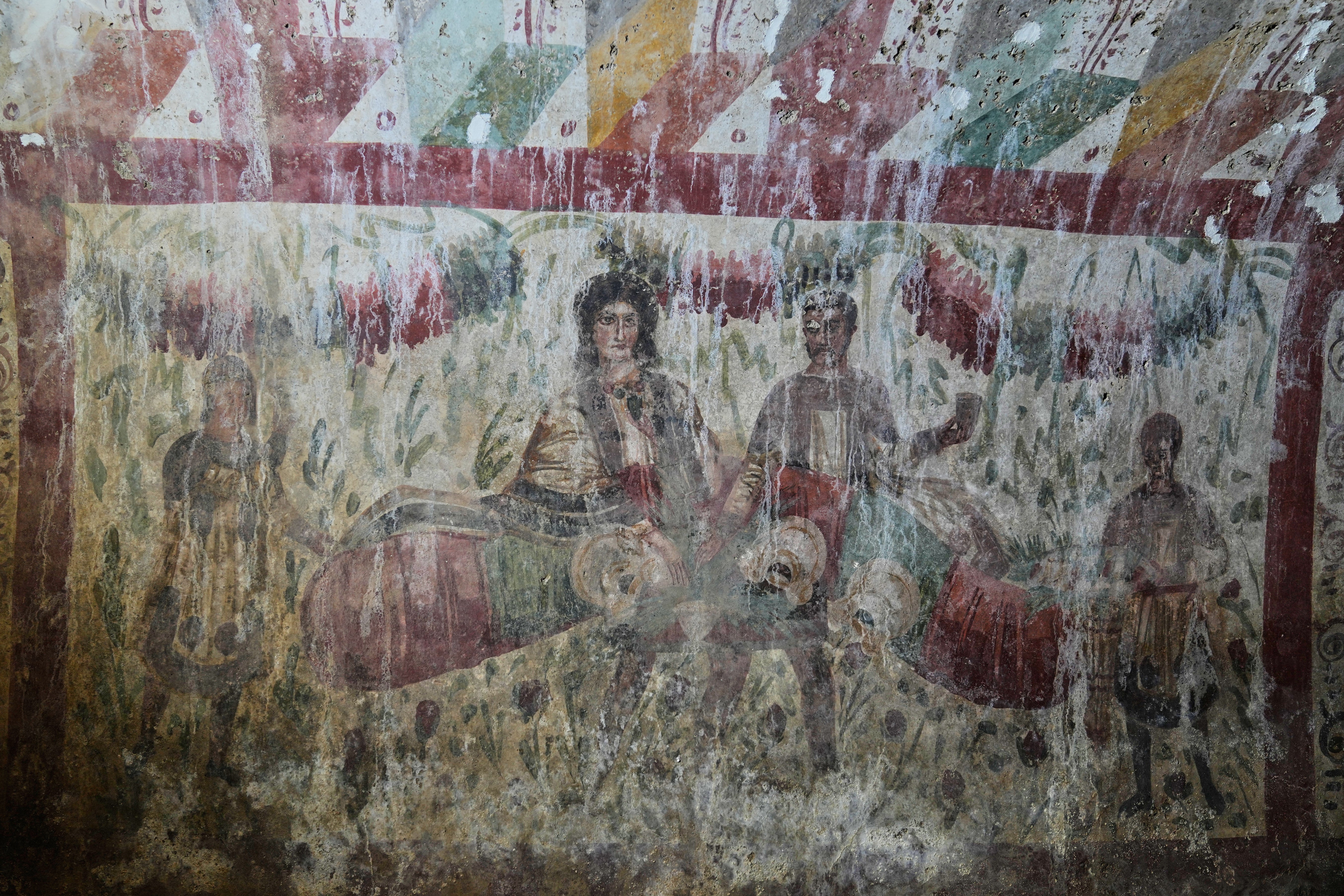 A Roman-era fresco depicting a banquet scene is seen inside a newly uncovered tomb in Hisardere, in Iznik in northwestern Turkey, Friday, Dec. 12, 2025. (AP Photo/Khalil Hamra)