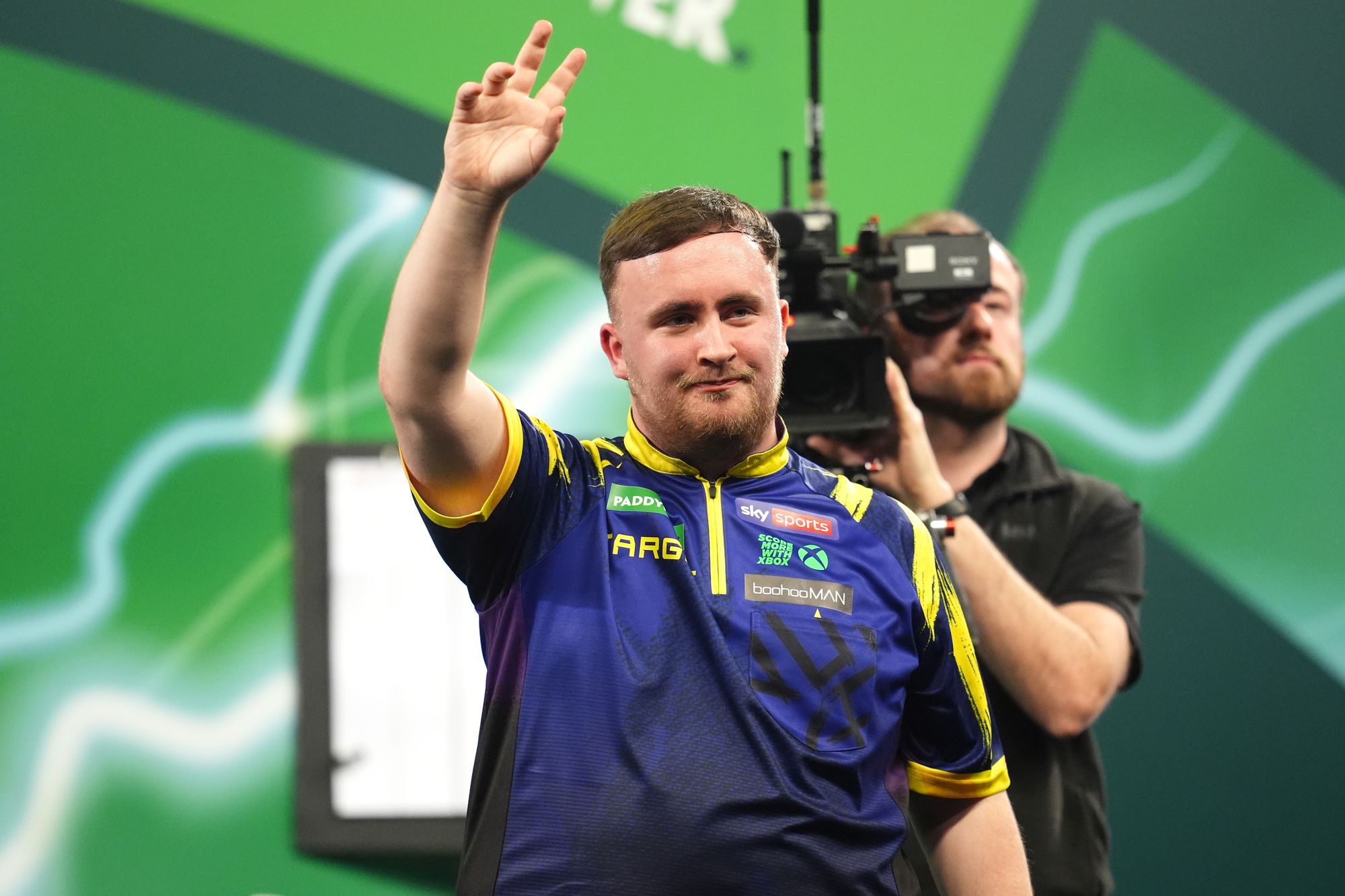 <p>Luke Littler acknowledges the crowd following victory against Darius Labanauskas on day one of the World Darts Championship</p>