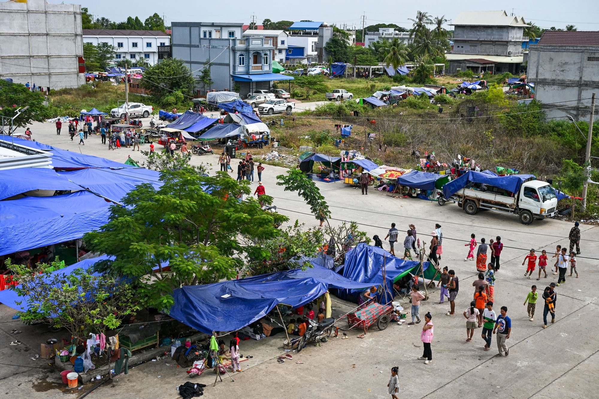 <p>Displaced residents walk at a temporary camp in Cambodia's Banteay Meanchey province on amid clashes along Cambodia-Thailand border</p>