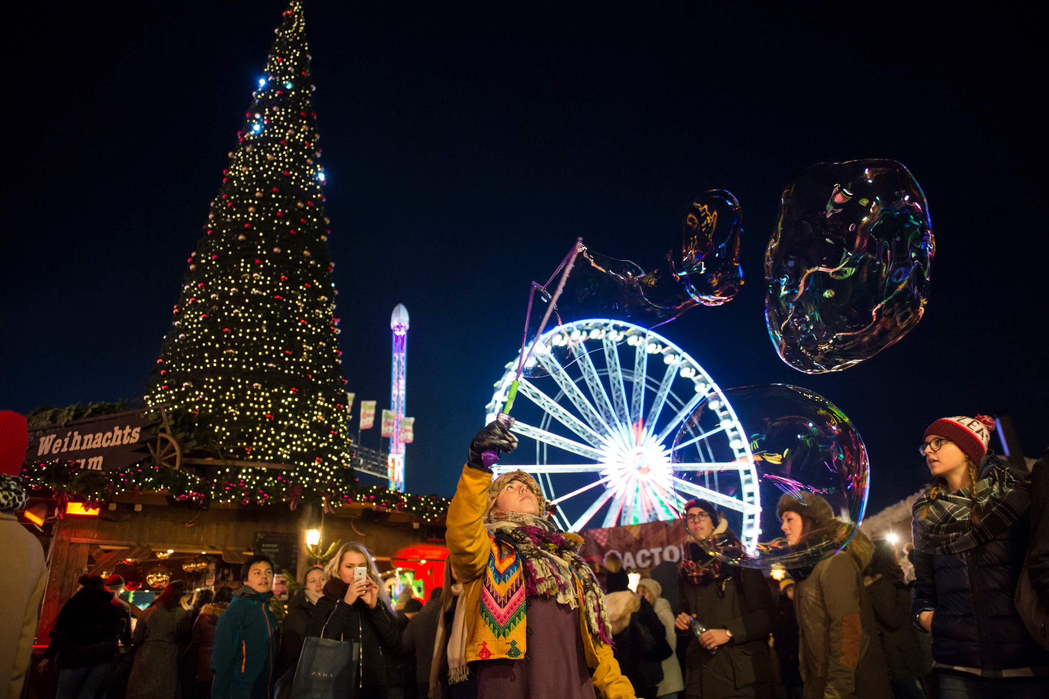 Visitors enjoy the rides and sights at Hyde Park Winter Wonderland in London (Ben Stevens/PA)