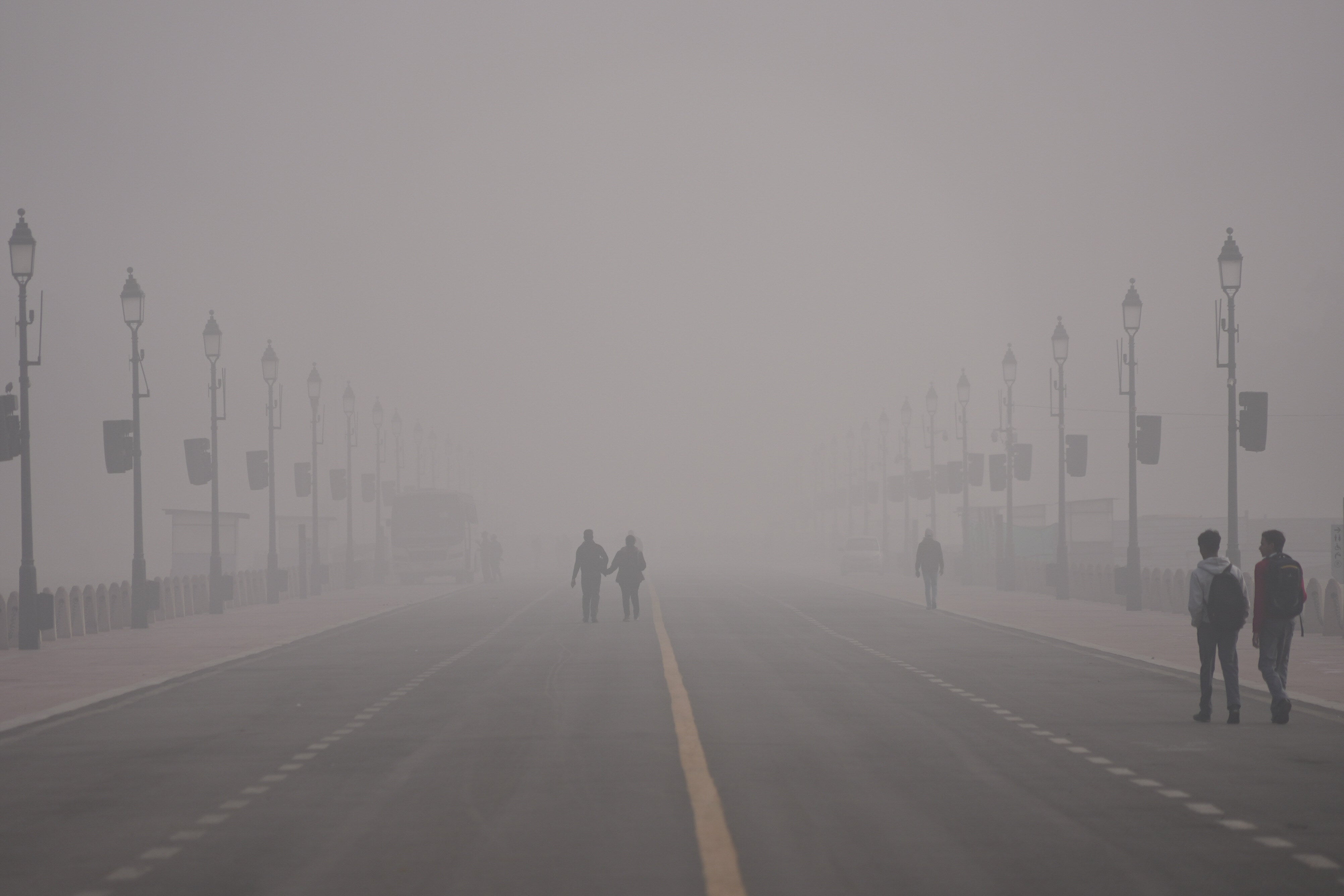 <p>People walk amid smog in Delhi on 15 December 2025</p>