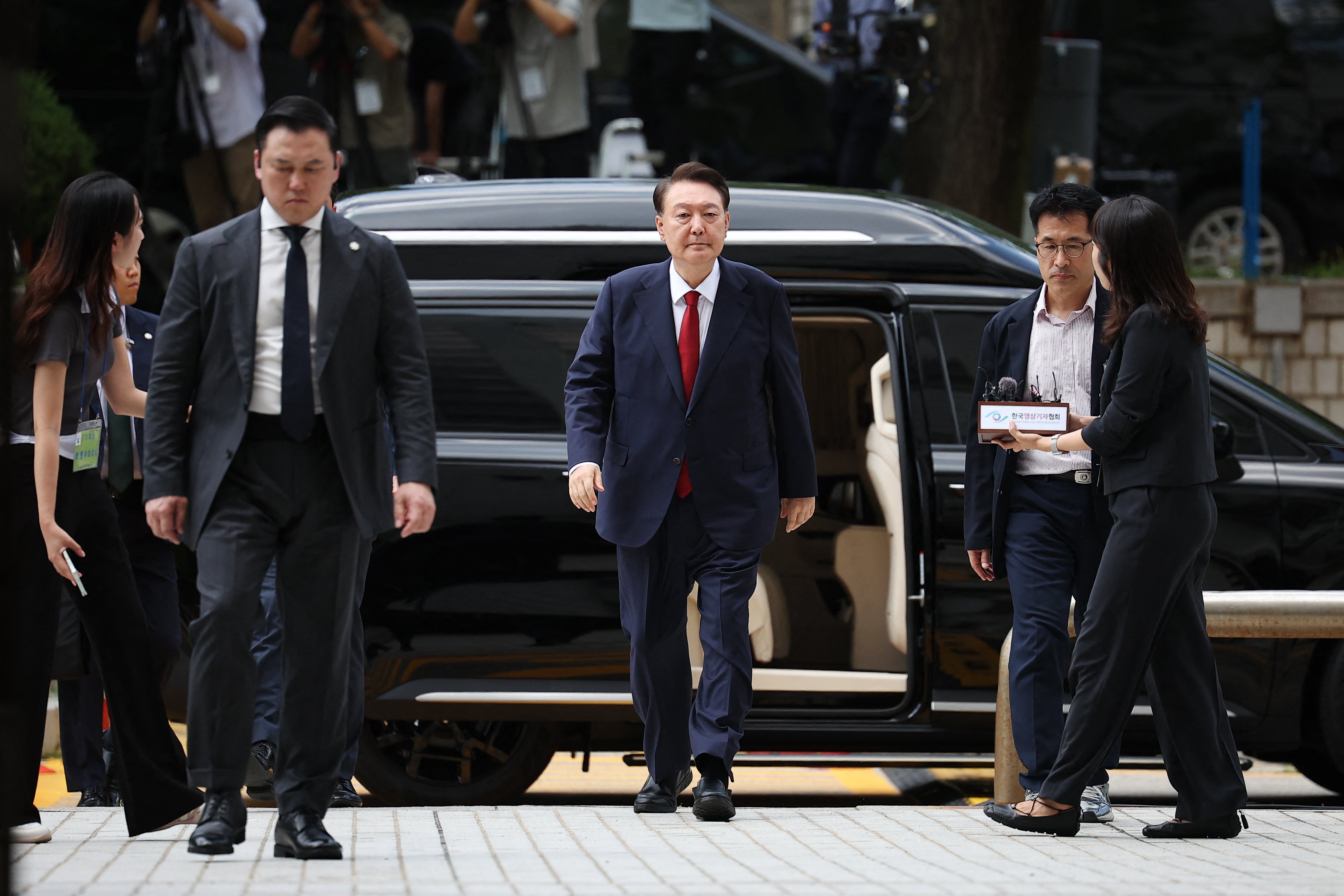 File. South Korea’s impeached president Yoon Suk Yeol, centre, arrives for a court hearing in Seoul on 9 July 2025