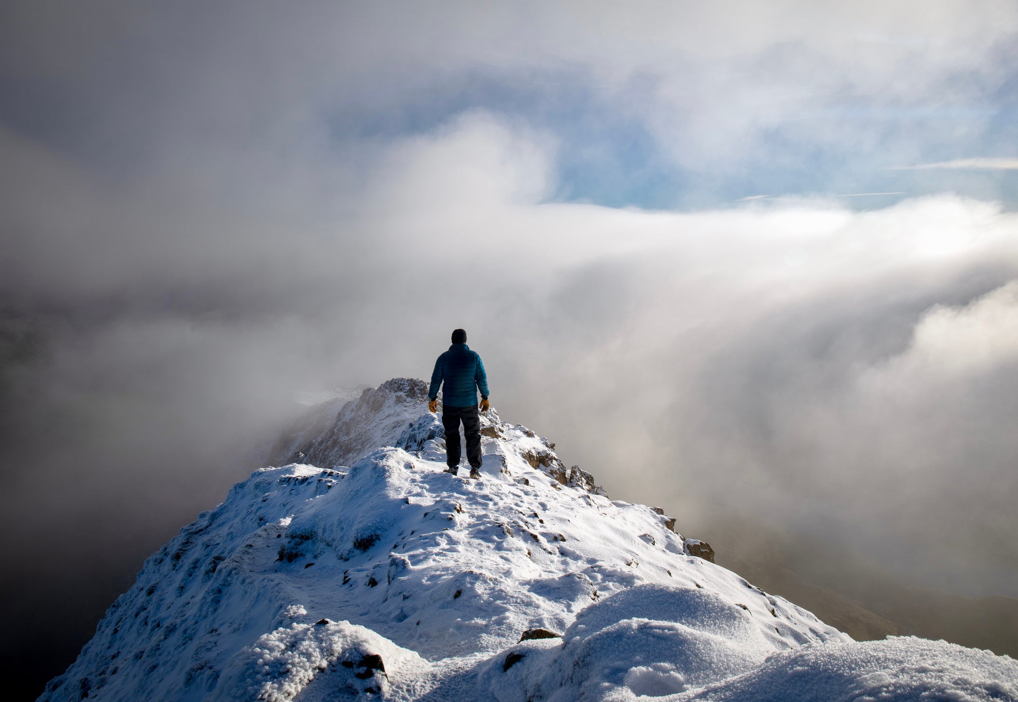 A hiker crosses a narrow ridge in Snowdonia National Park, Wales, where rescues call outs have shot up
