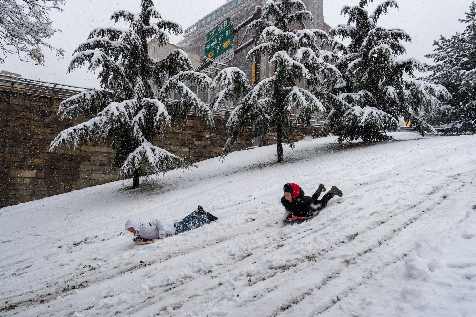Kids sled down in a hill after a winter storm in new York City