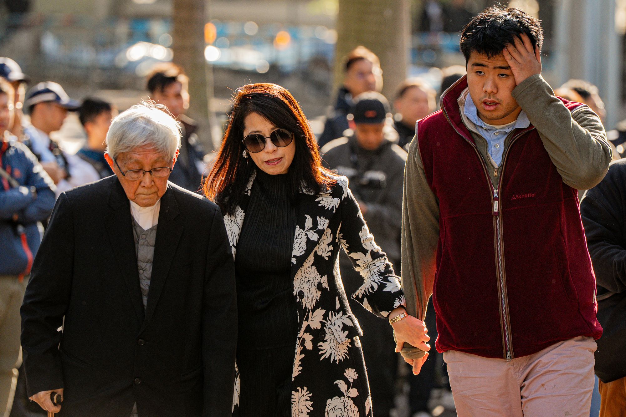 Teresa Lai (C) and Lai Shun-yan (R), the wife and son of pro-democracy media tycoon Jimmy Lai, and Cardinal Joseph Zen (L), the former bishop of Hong Kong, arrive at the West Kowloon Law Courts building for Lai's expected verdicts in the national security trial in Hong Kong
