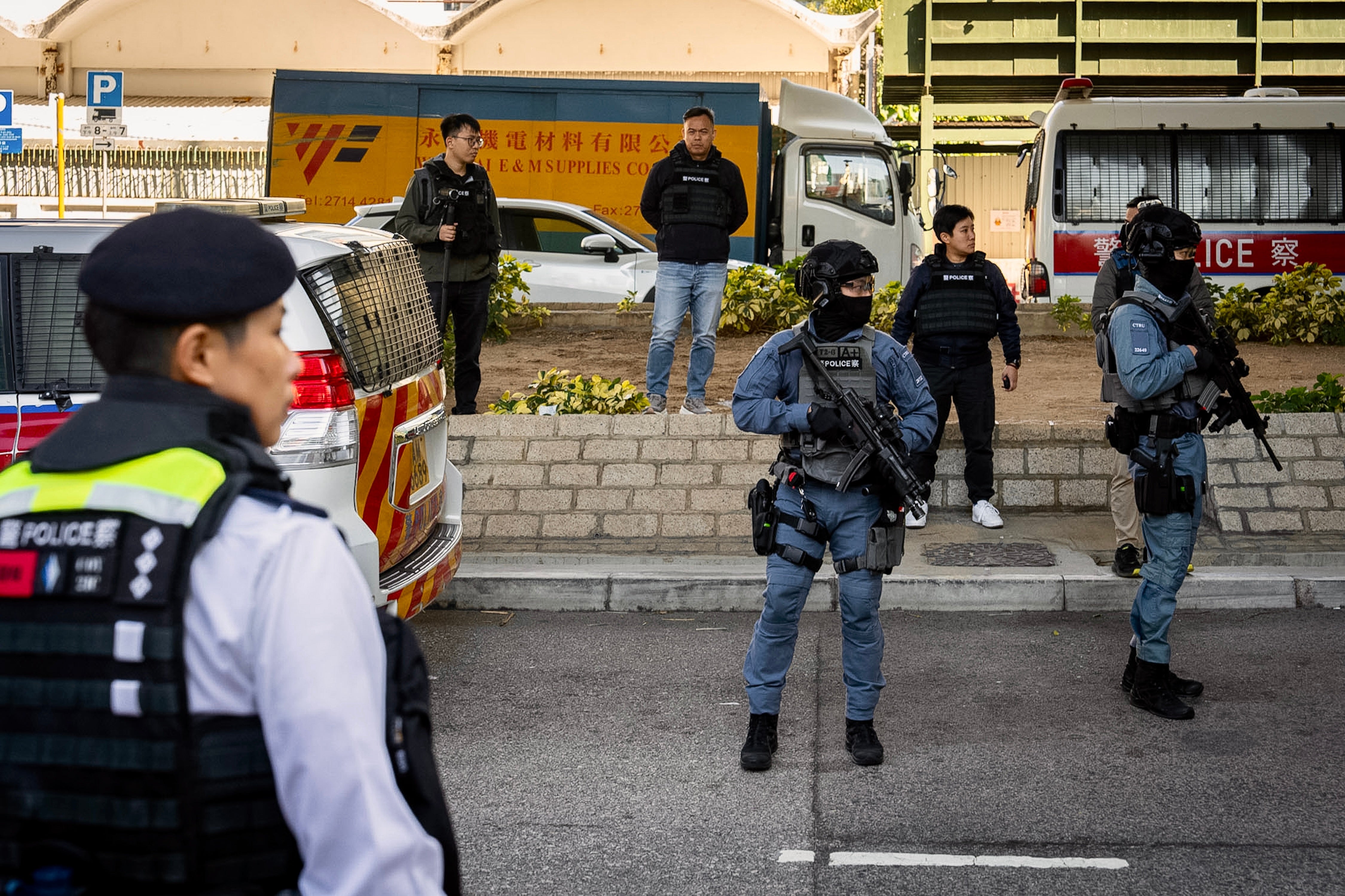 Armed police stand guard outside the West Kowloon Magistrates' Courts following the verdict for Hong Kong activist publisher Jimmy Lai's national security trial in Hong Kong, Monday