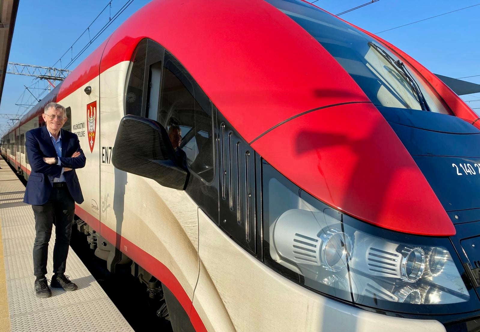 <p>Cheap and cheerful: Simon Calder beside a Polish express train</p>