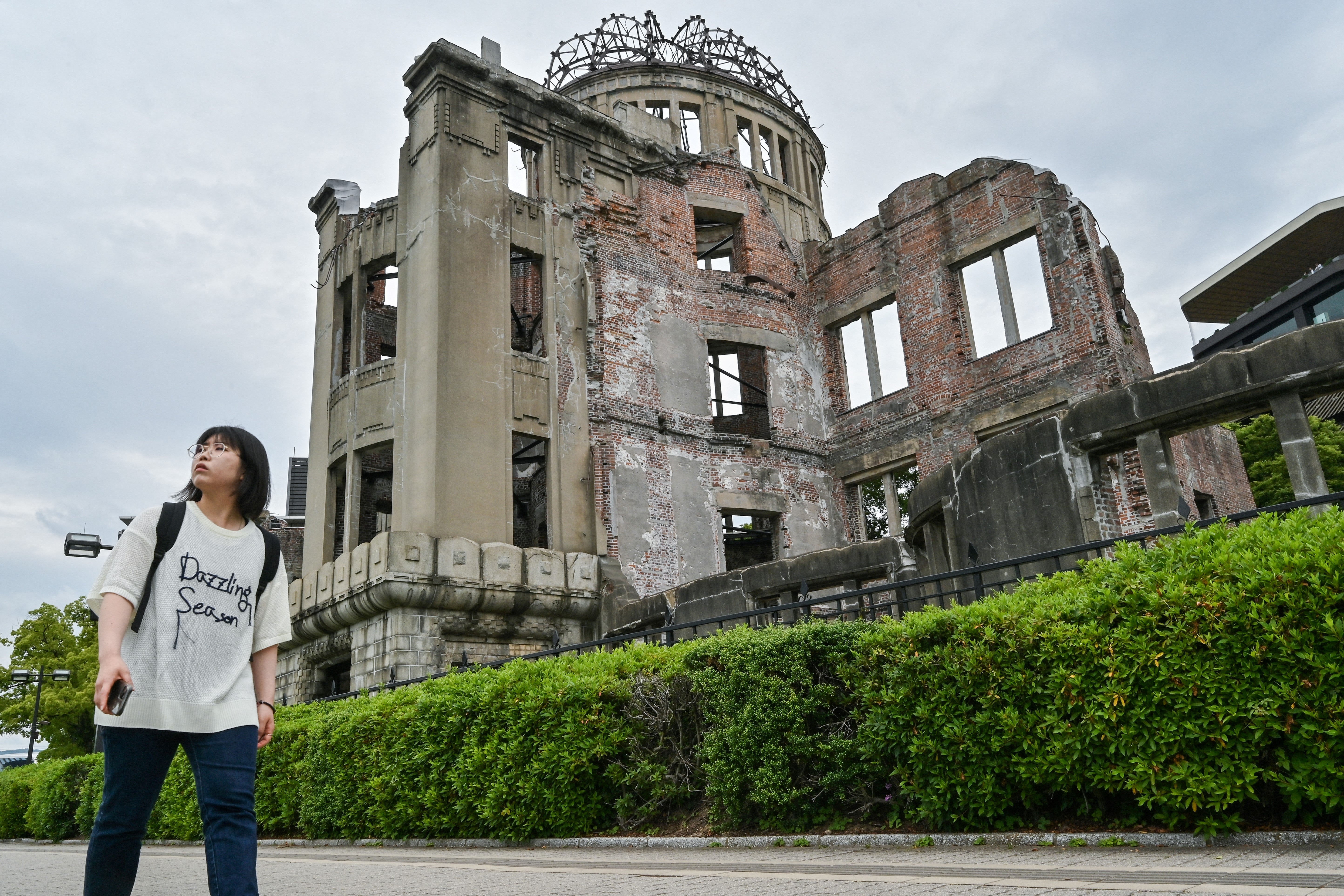 A woman walks past the Atomic Bomb Dome in the centre of Hiroshima on 30 May 2025