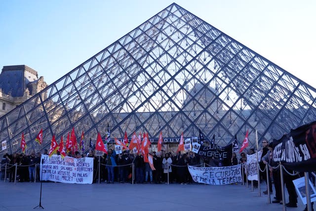 <p>Workers display banners outside the Louvre museum after they voted to strike for the day over working conditions and other complaints</p>