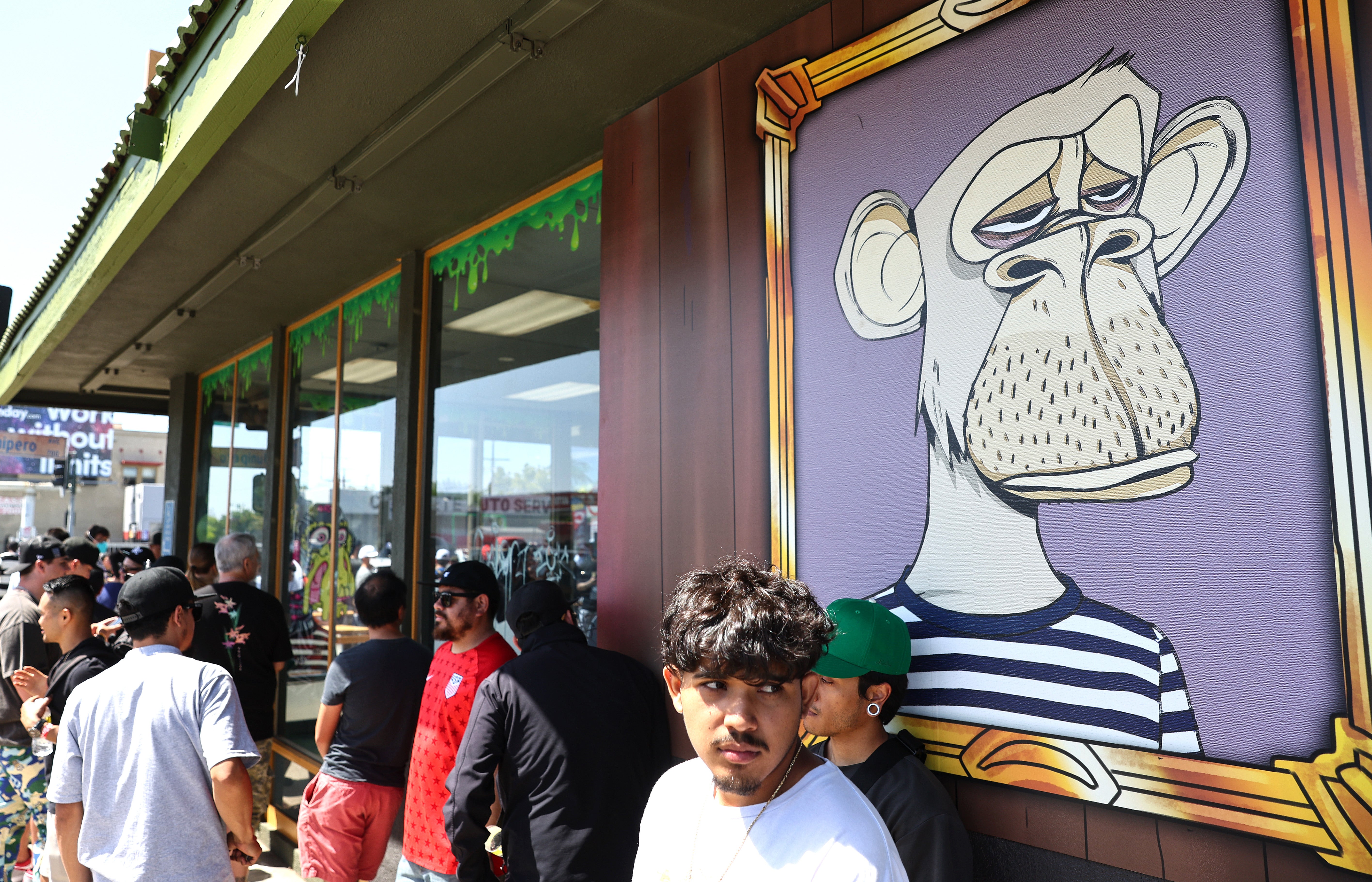 People wait in line at the grand opening of a Bored Ape NFT themed burger restaurant in Long Beach, California, in April 2022