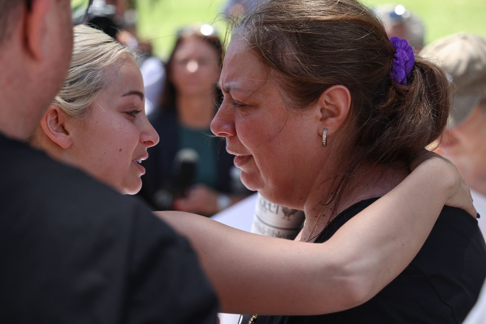 A woman consoles Valentyna (R), mother of ten-year-old Matilda, who was killed in the 14 December 2025 Bondi Beach shooting attack, as she spoke to local media outside Bondi Pavilion in Sydney on 17 December 2025