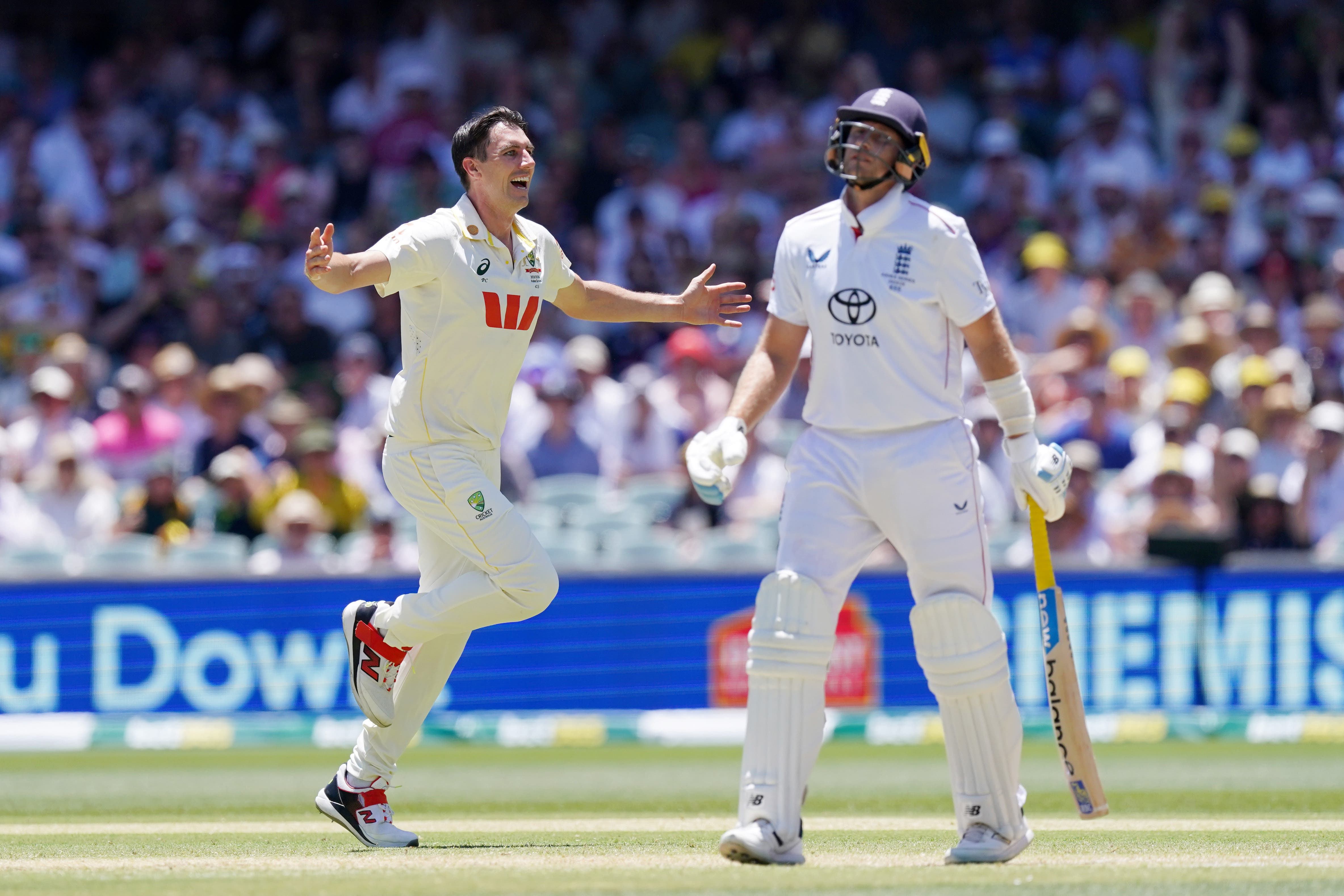 Australia’s Pat Cummins, left, celebrates taking the wicket of England’s Joe Root (Robbie Stephenson/PA)