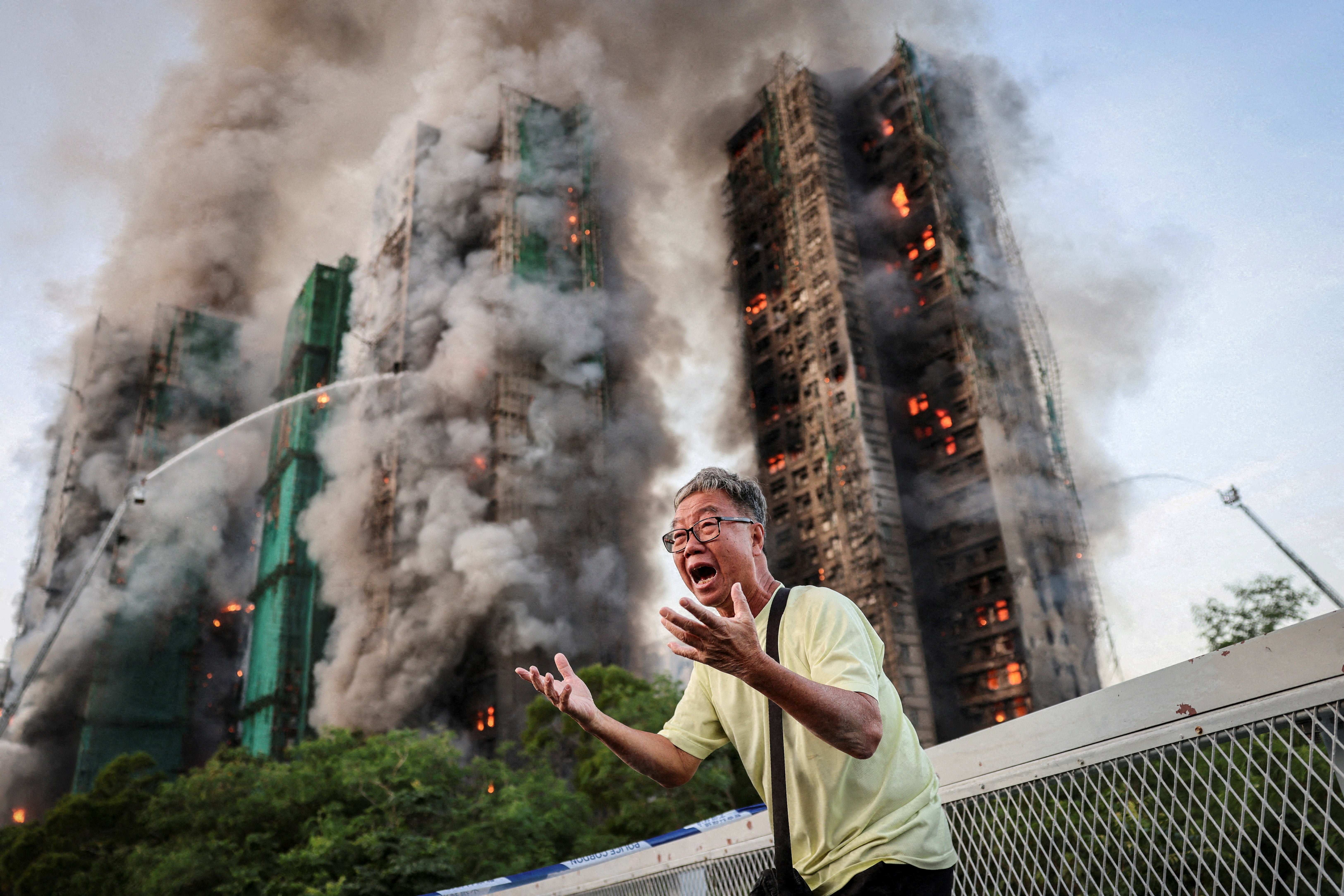 Wong, 71, reacts after saying his wife is trapped inside the Wang Fuk Court complex during a major fire in Hong Kong, China