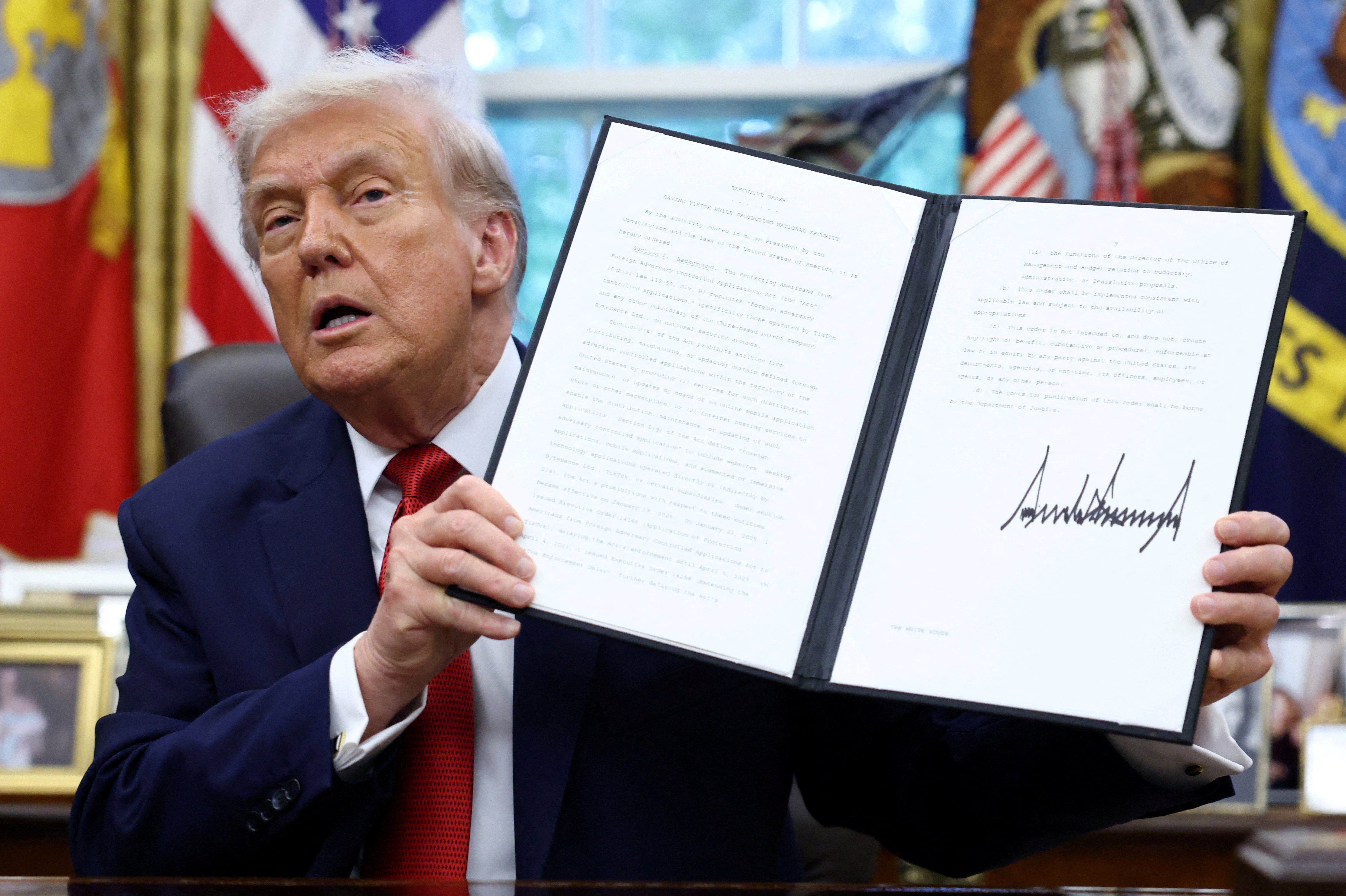 Donald Trump pictured with signed executive orders at the White House earlier this year