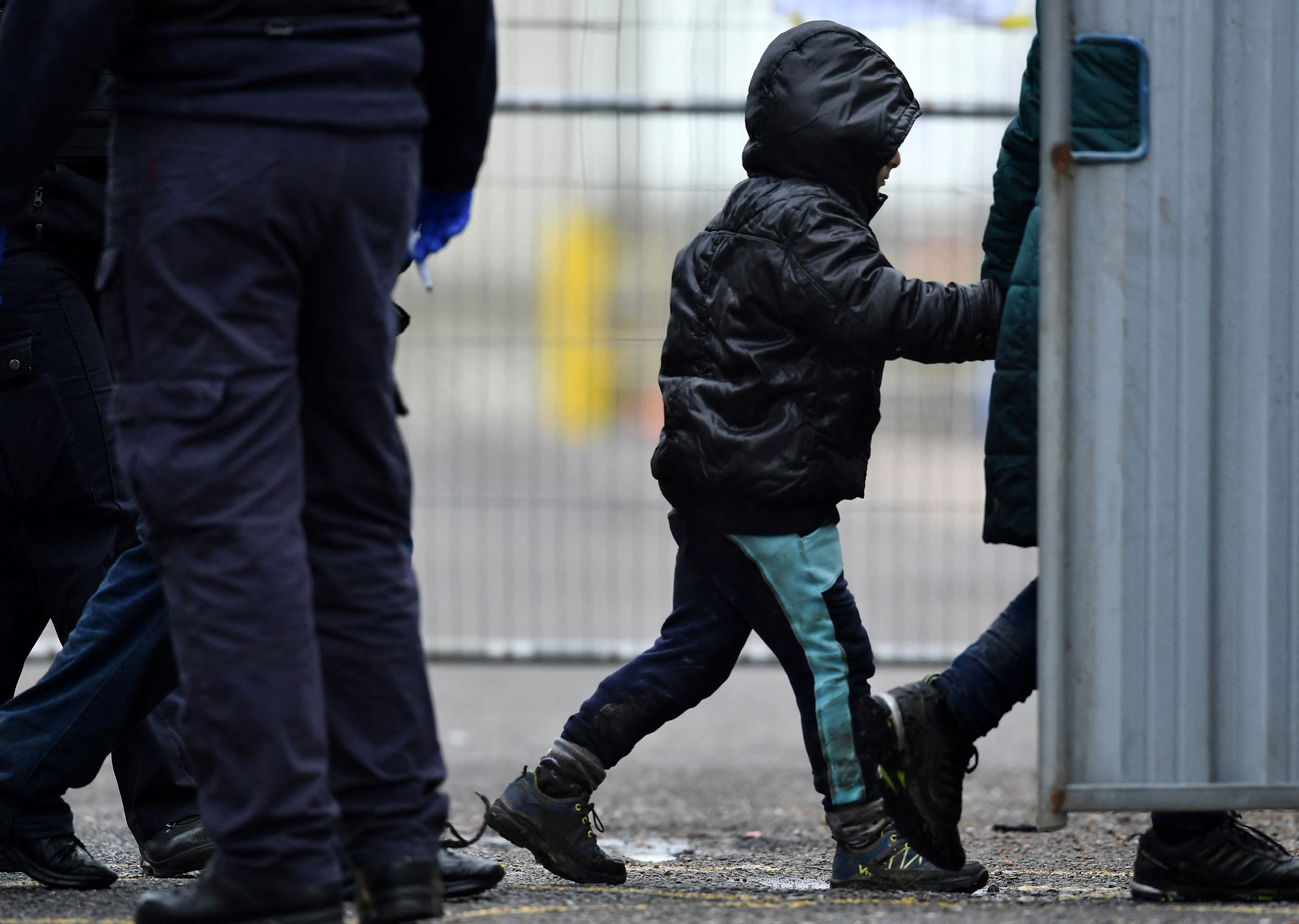 A UK Immigration Enforcement officer escorts a child migrant, picked up at sea attempting to cross the English Channel, on arrival in Dover, on 10 January 2022