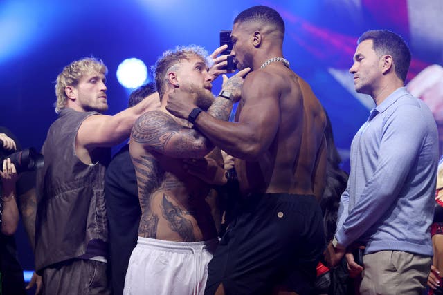 <p>Jake Paul (centre-left) and Anthony Joshua face off for the final time before their fight</p>