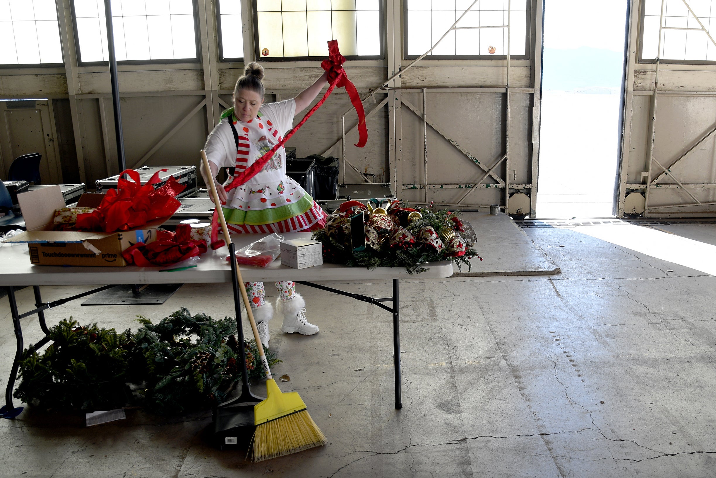 Designer Michelle Reid prepares holiday decorations inside a hangar at Peterson Space Force Base