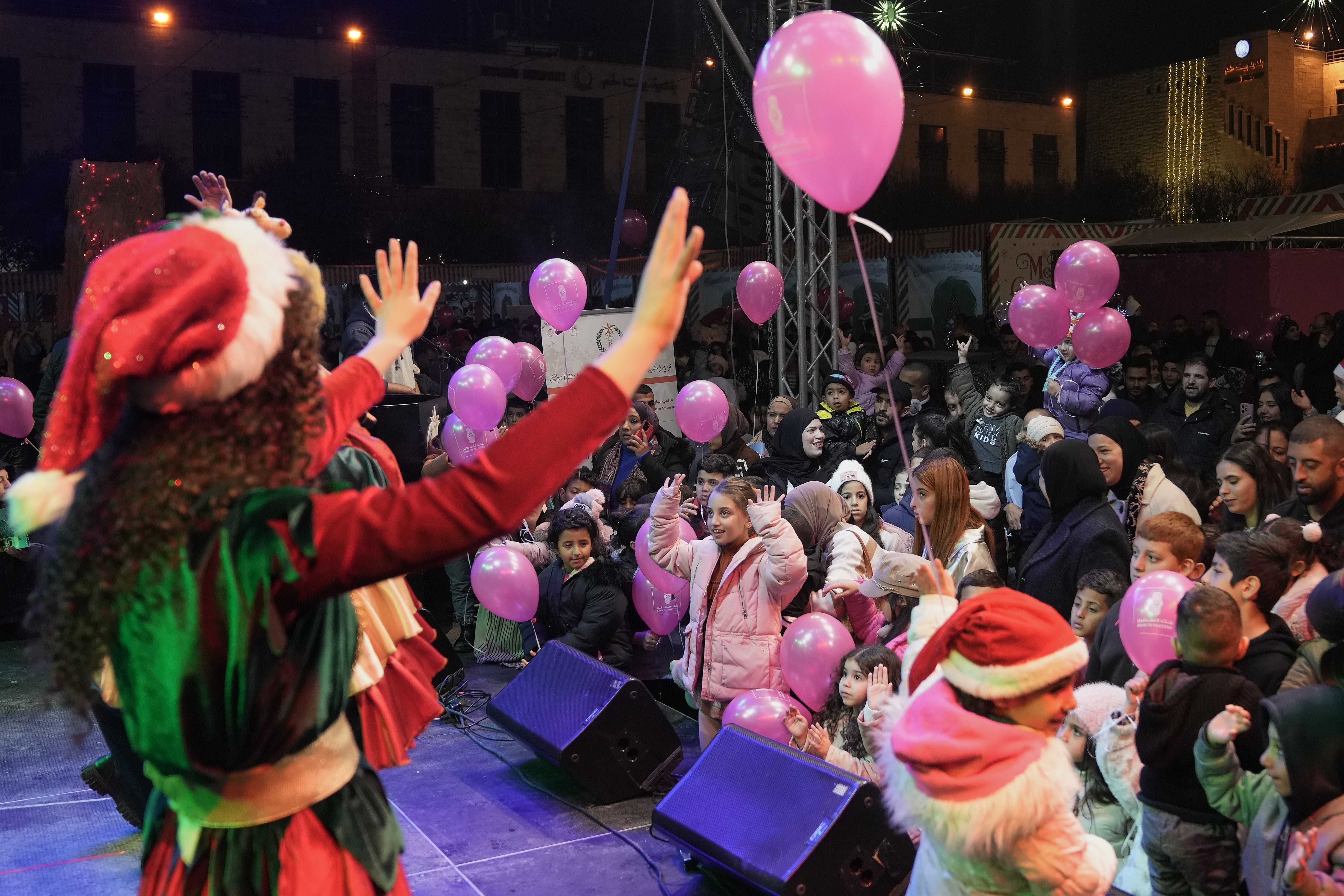 Palestinians watch performances in Manger Square in the West Bank city of Bethlehem, Friday, Dec. 12, 2025. (AP Photo/Mahmoud Illean)