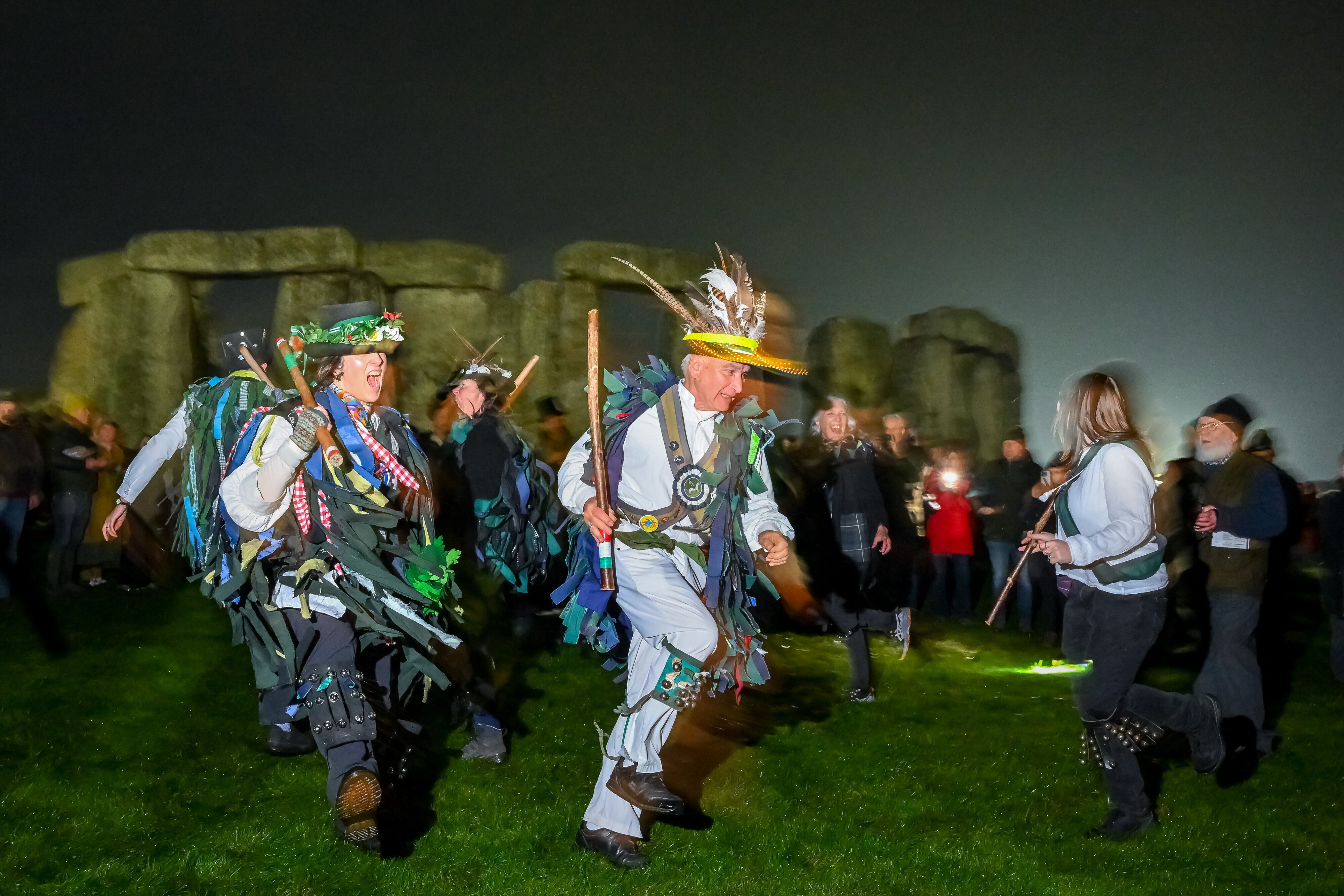 People celebrate the Winter Solstice sunrise celebrations at Stonehenge, a world-famous prehistoric monument on Salisbury Plain, England, Sunday, Dec. 21, 2025