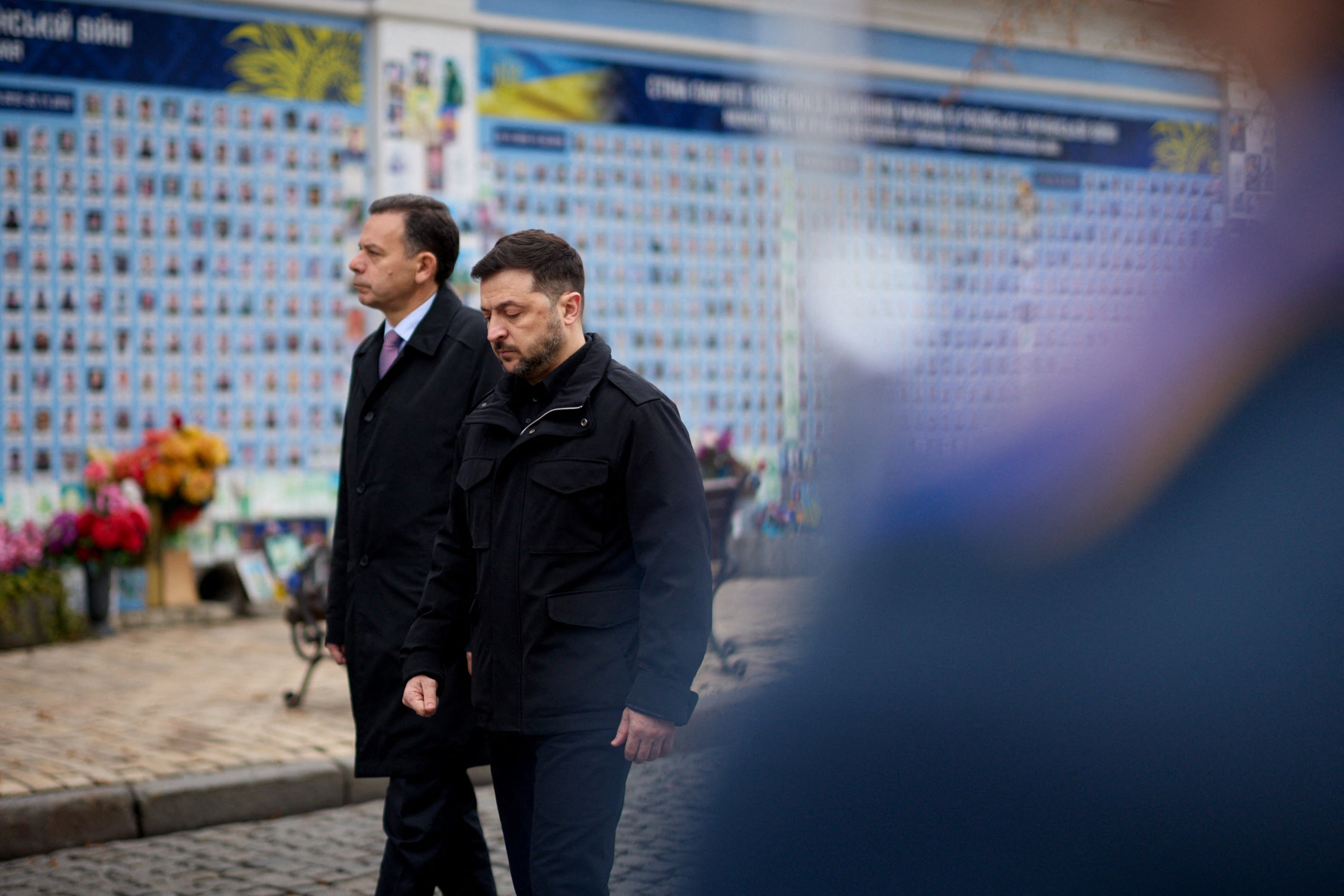 In this handout photograph taken and released by the Ukrainian Presidential Press Service on December 20, 2025, Ukraine's President Volodymyr Zelensky (R) and Portugal's Prime Minister Luis Montenegro (L) attend a wreath-laying ceremony at the Memory Wall of Fallen Ukrainian Defenders, in Kyiv, amid the Russian invasion of Ukraine
