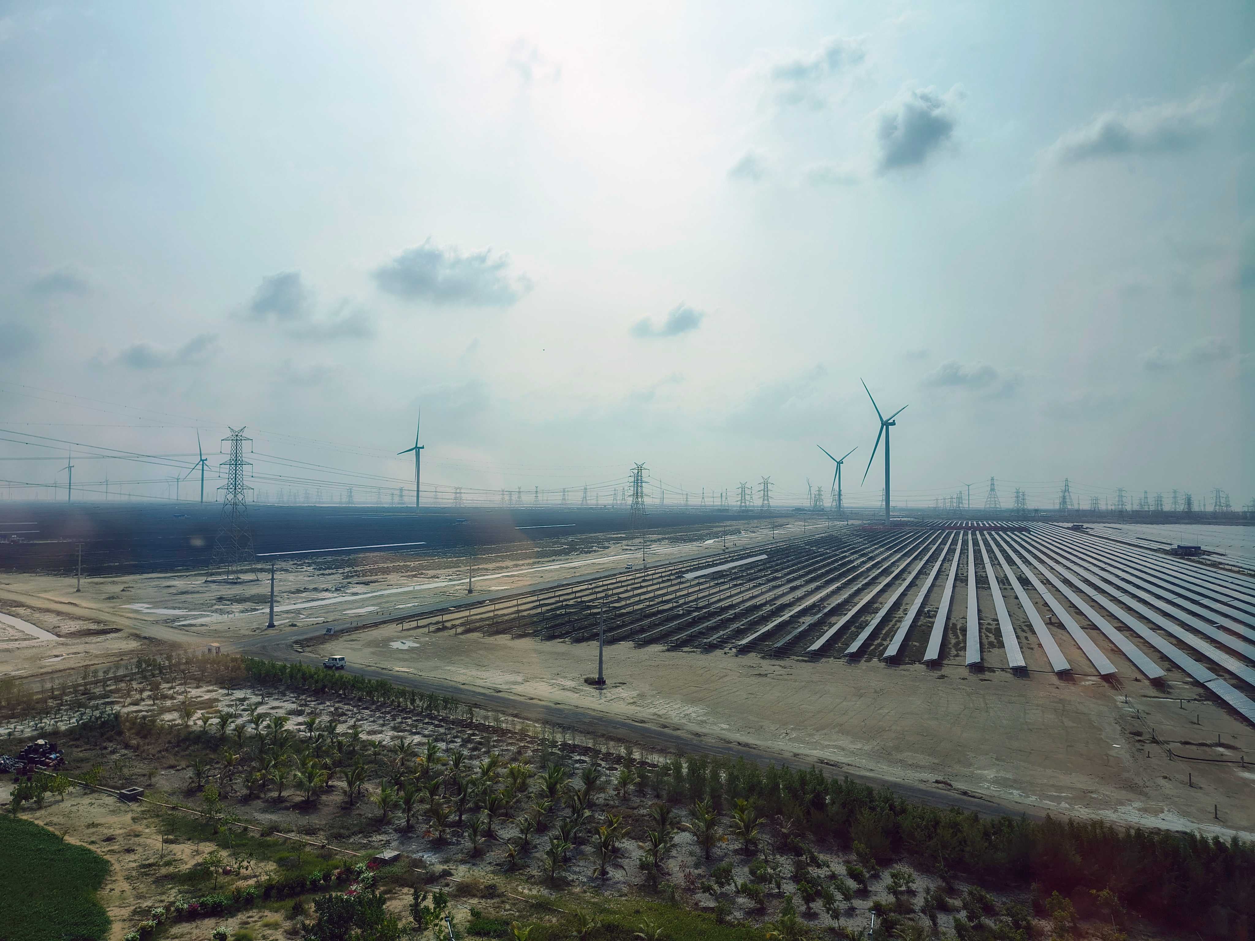 A view of Khavda renewable energy park with rows of solar panels and wind turbines