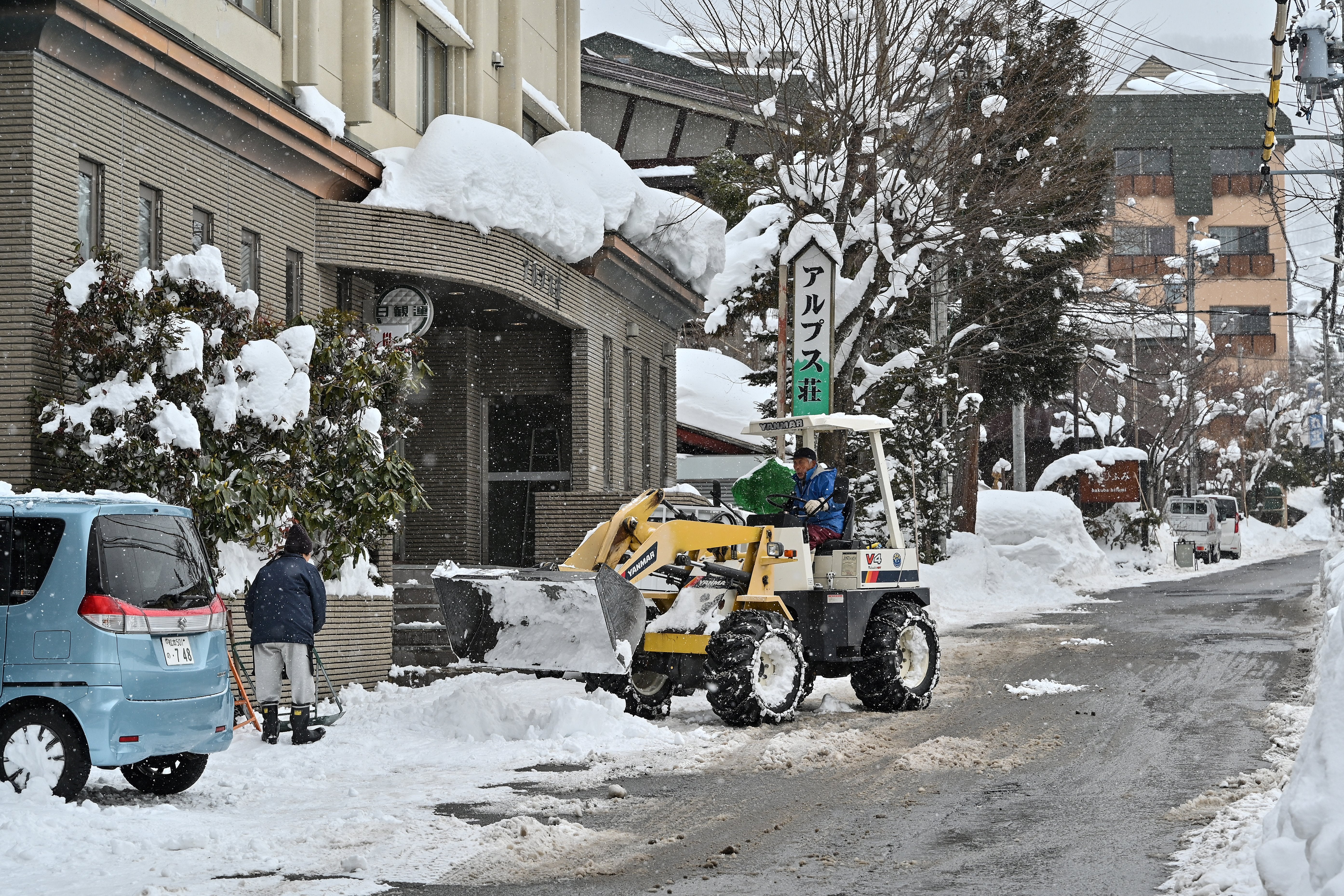 <p>A man using heavy machinery to clear snow from a street in the ski resort town of Hakuba, Nagano prefecture</p>