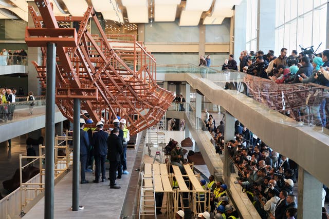 <p>People film archeologists as they reassemble the second solar boat of King Khufu, at the Grand Egyptian Museum in Giza, Egypt, Tuesday, Dec. 23, 2025. (AP Photo/Amr Nabil)</p>