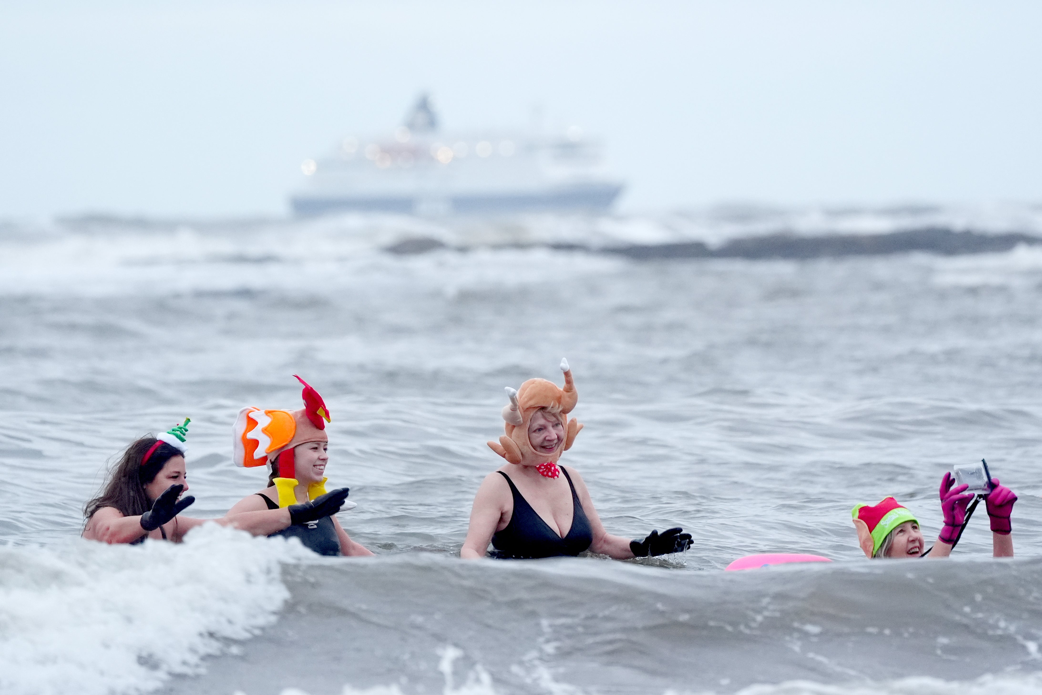 People enjoying a swim on Christmas Eve at Cullercoats Bay in North Tyneside (Owen Humphreys/PA)