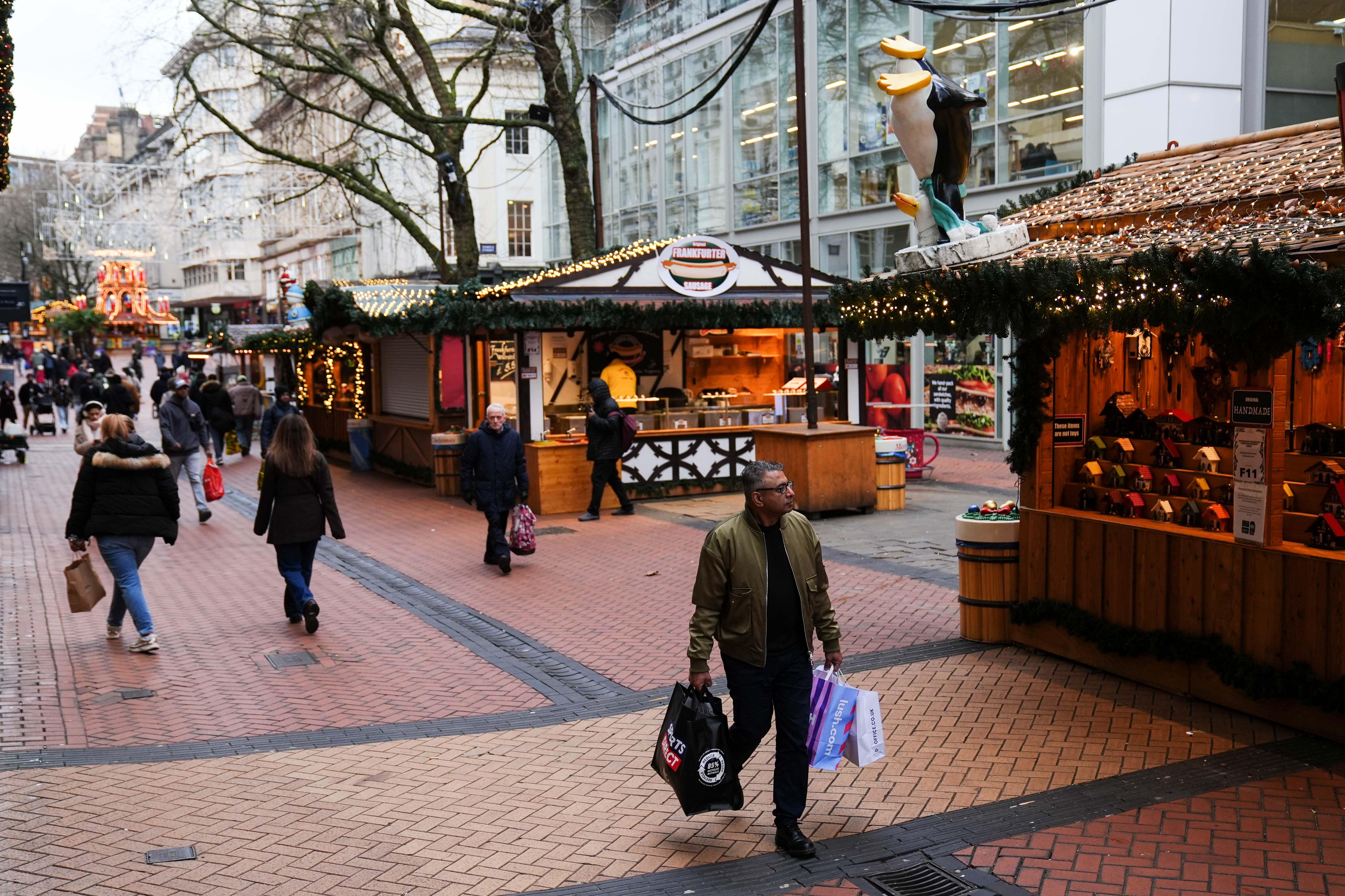 People in Birmingham’s New Street do some last-minute Christmas shopping on Christmas Eve (Jacob King/PA)