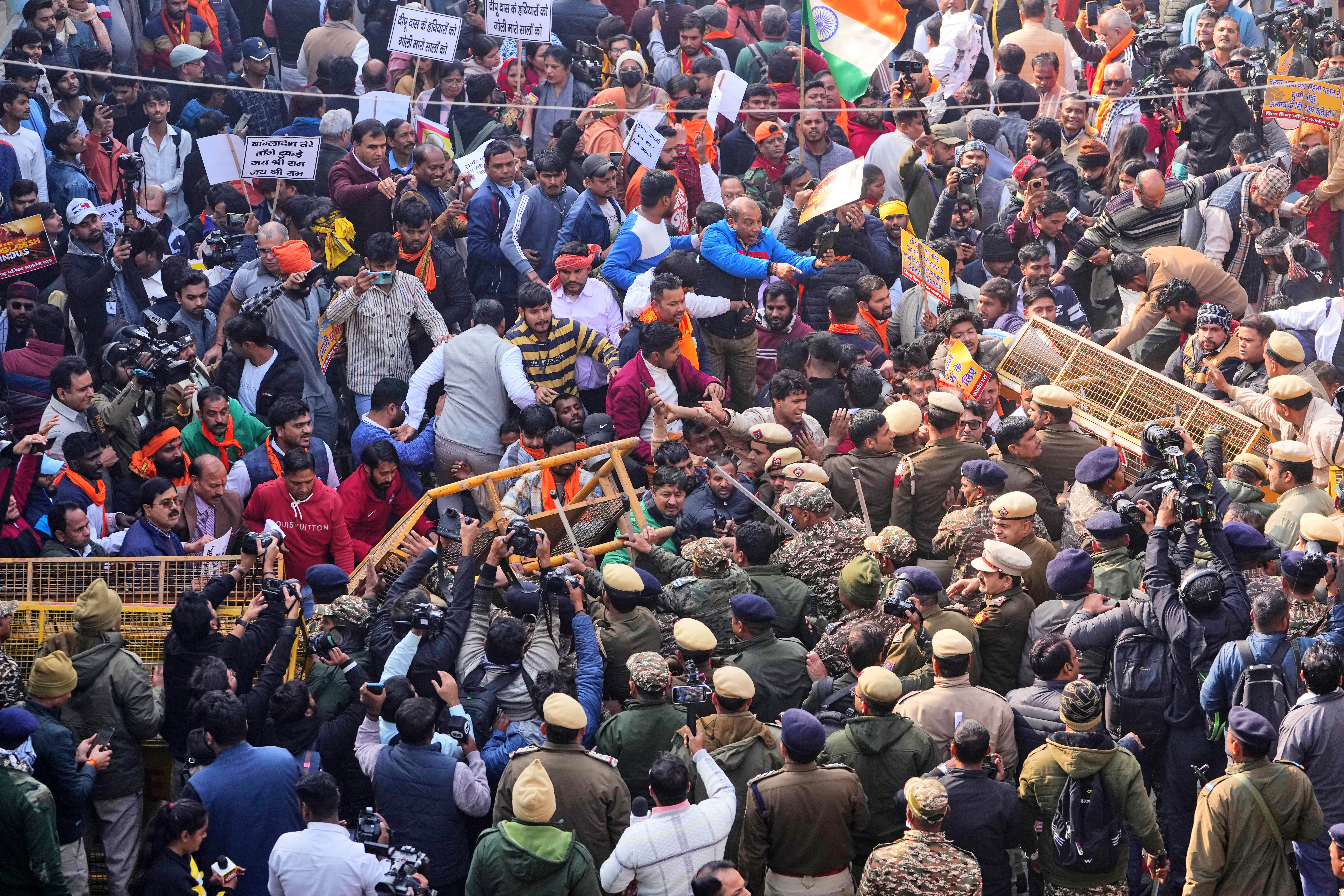 Police officers try to stop activists of Vishwa Hindu Parishad, a prominent right-wing Hindu nationalist organisation, crossing over barricades during a protest near Bangladesh High Commission