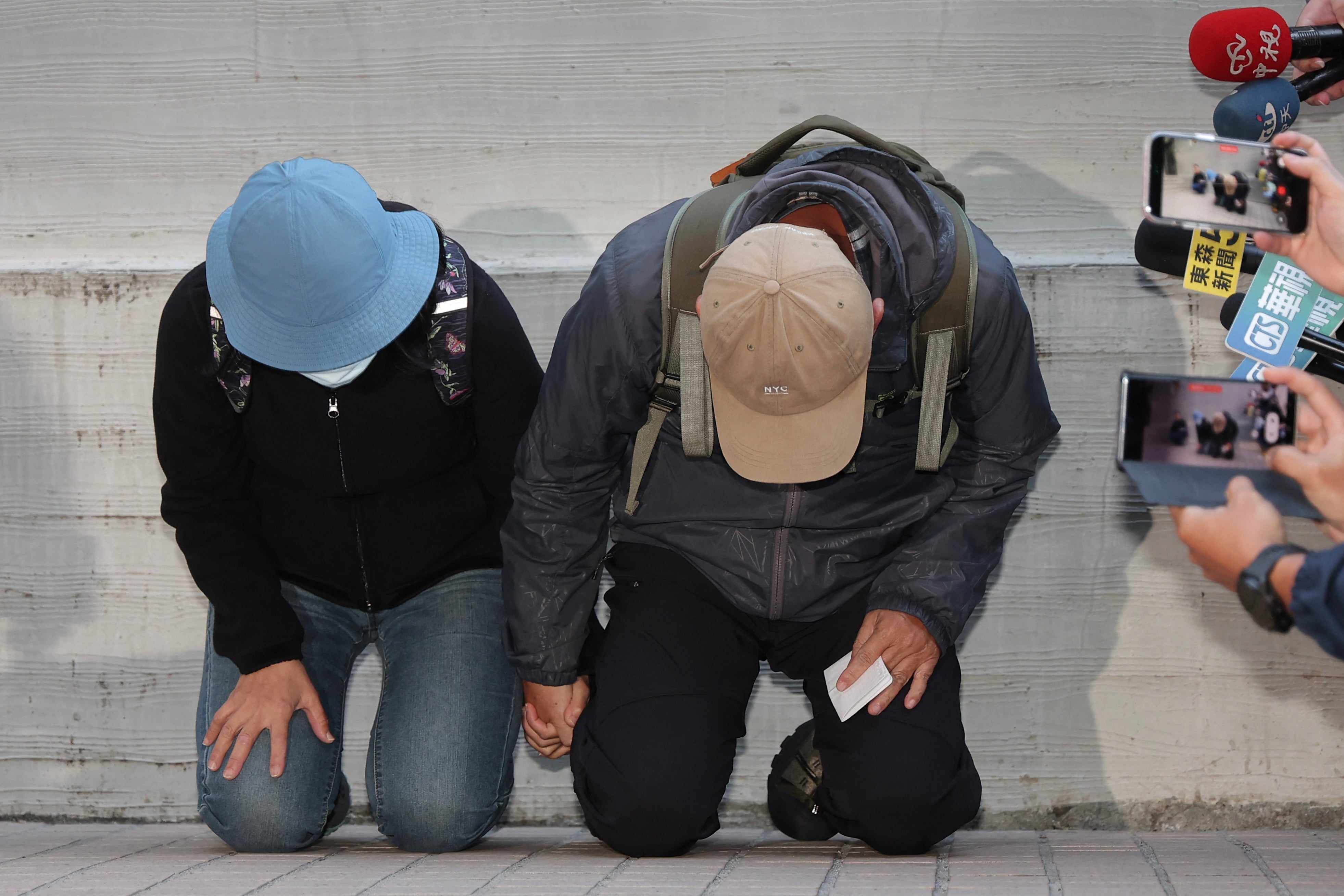 <p>This picture taken and released by Central News Agency (CNA) on 23 December 2025 shows the parents of the suspect in the 19 December Taipei metro stabbings where the attacker killed three and wounded 11, identified by police by his family name Chang and who was later found dead after jumping off a nearby building, kneeling in apology during their appearance at the Taipei City Forensic Inspection and Autopsy Center</p>