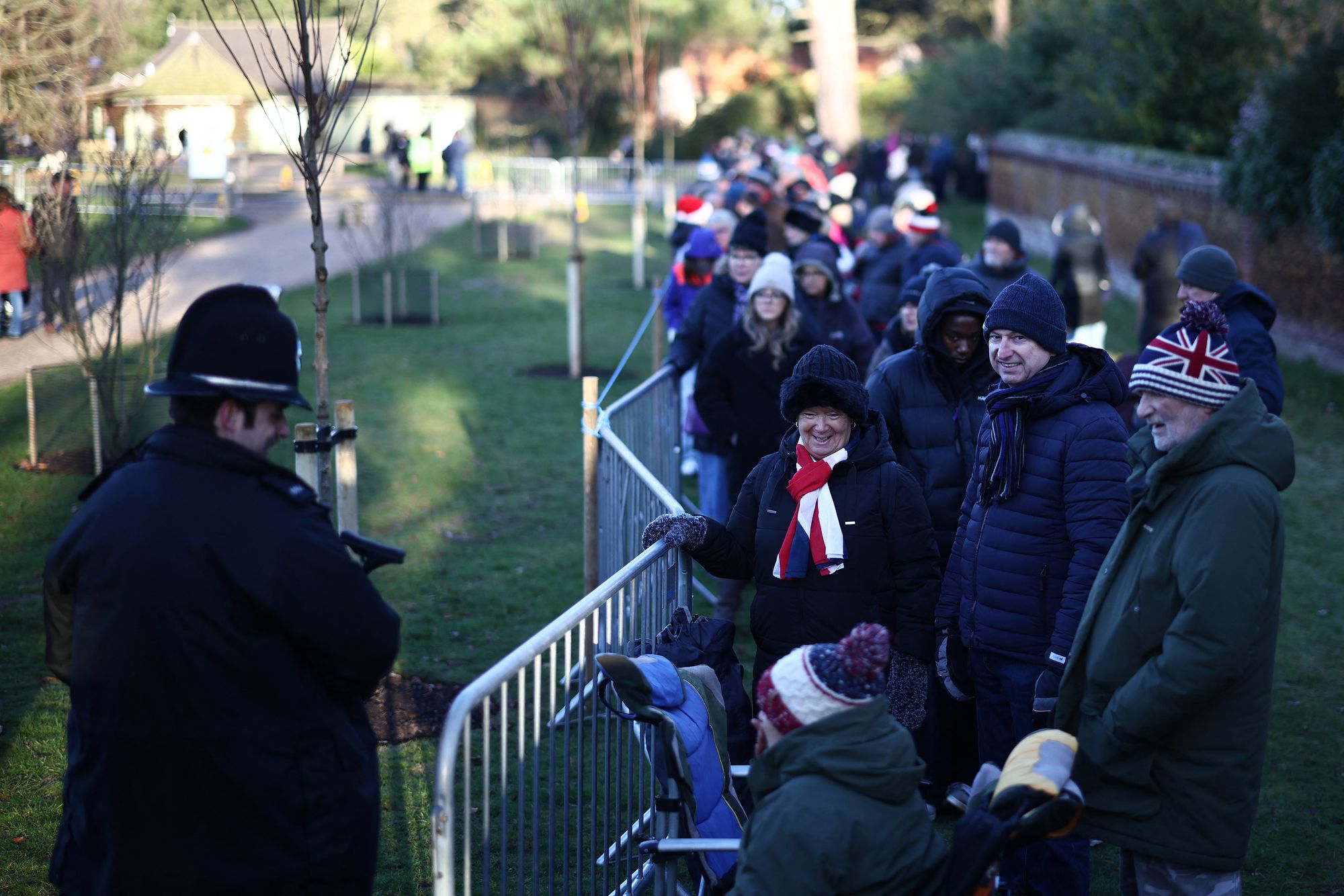 Well-wishers wait for members of the British Royal Family to arrive to attend the traditional Christmas Day service at St Mary Magdalene Church.