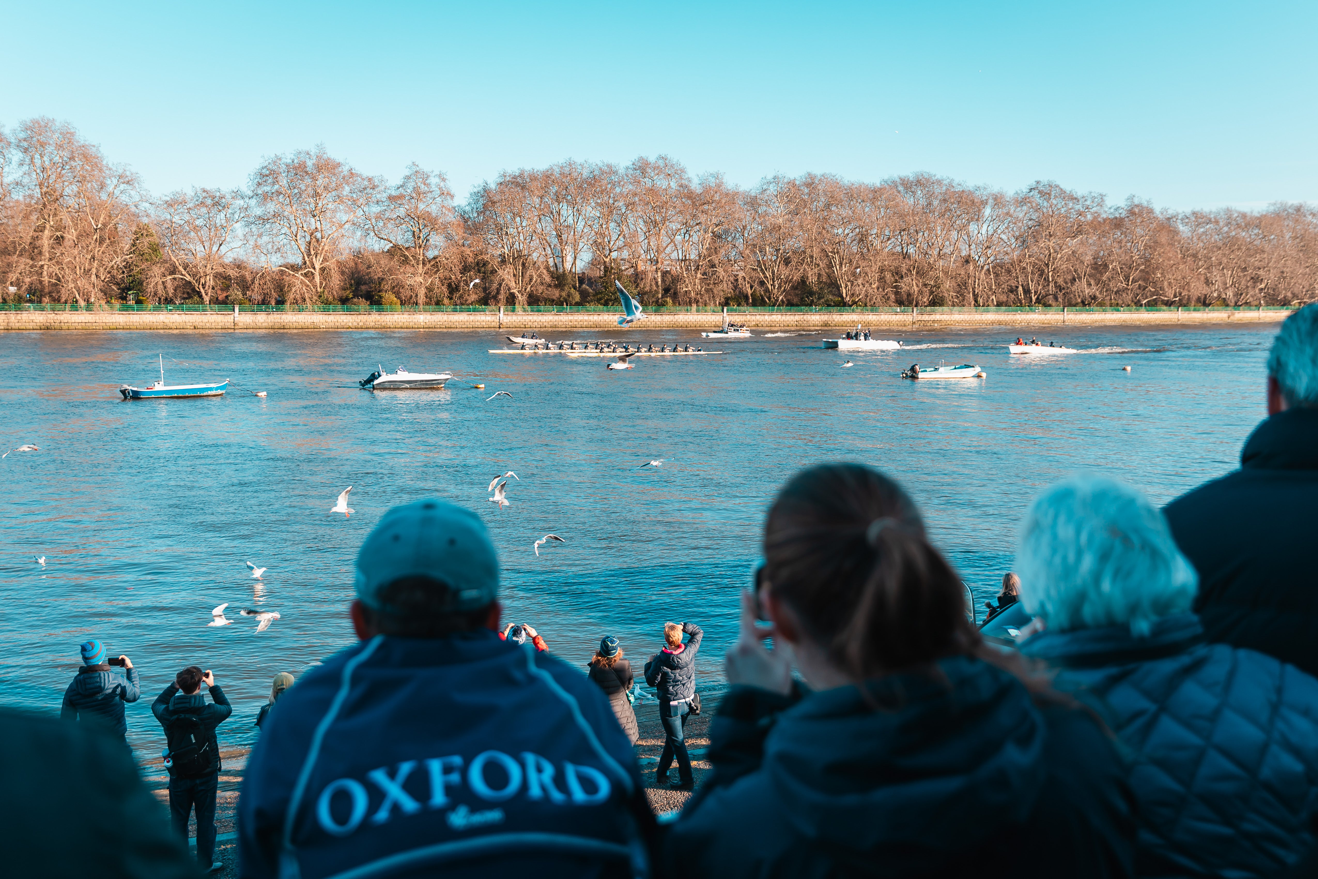 Friends and family watch on from the shore while the rowers are followed by the umpires’ boat, coaches, and a media boat