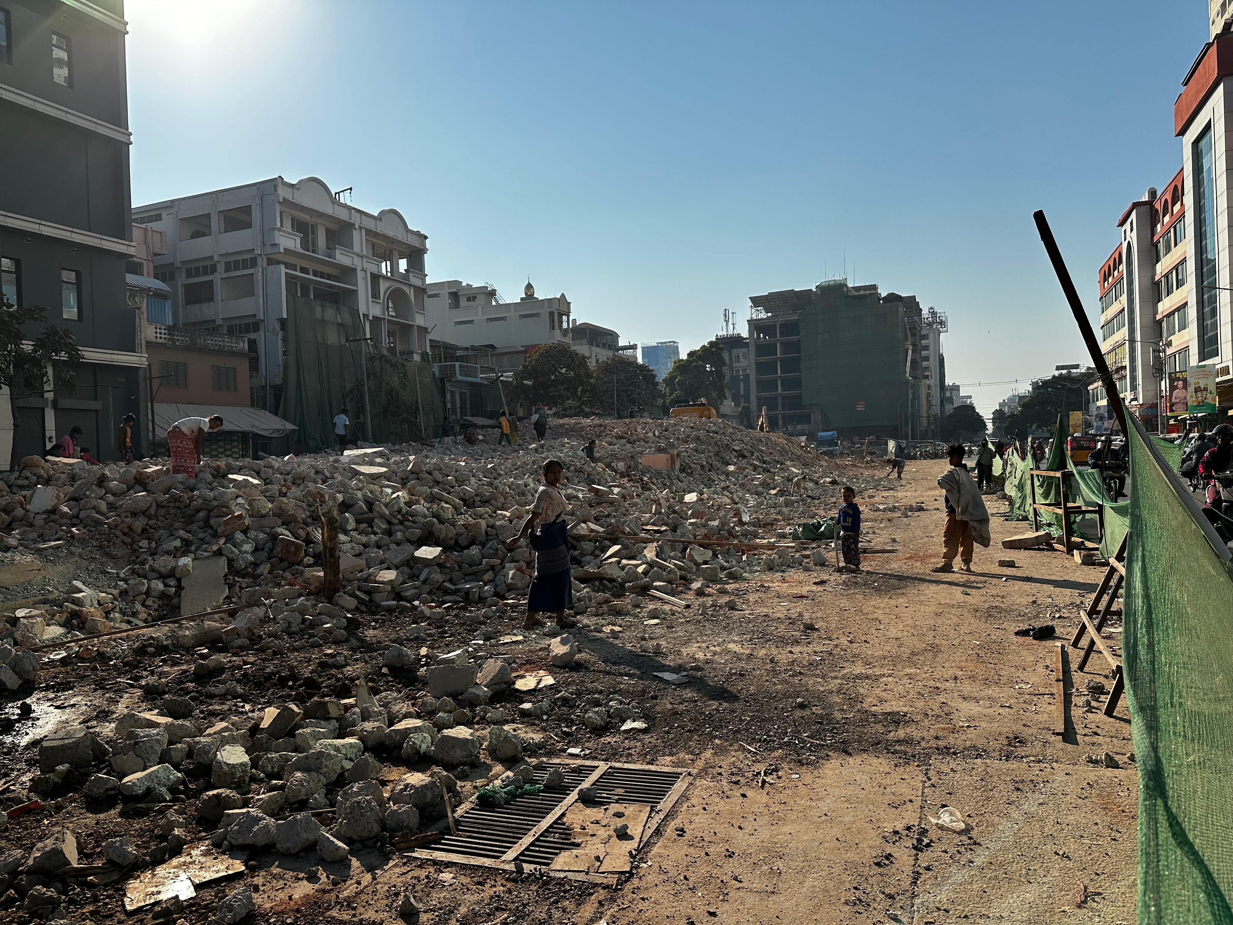 A family works on the site of a building destroyed by the earthquake in Mandalay