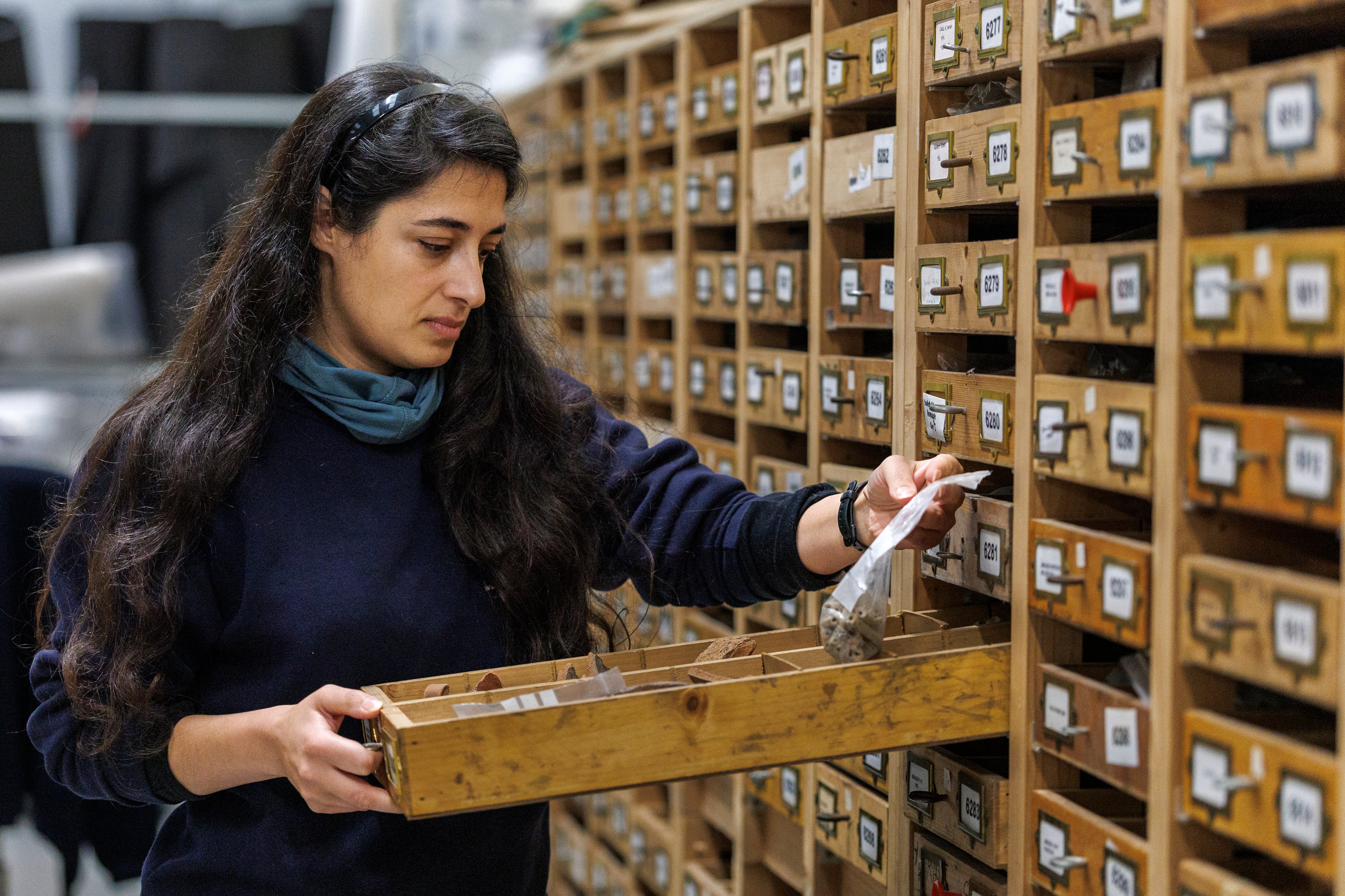 Sapphire Mussen examines artefacts held at the archaeological store (Liam McBurney/PA).