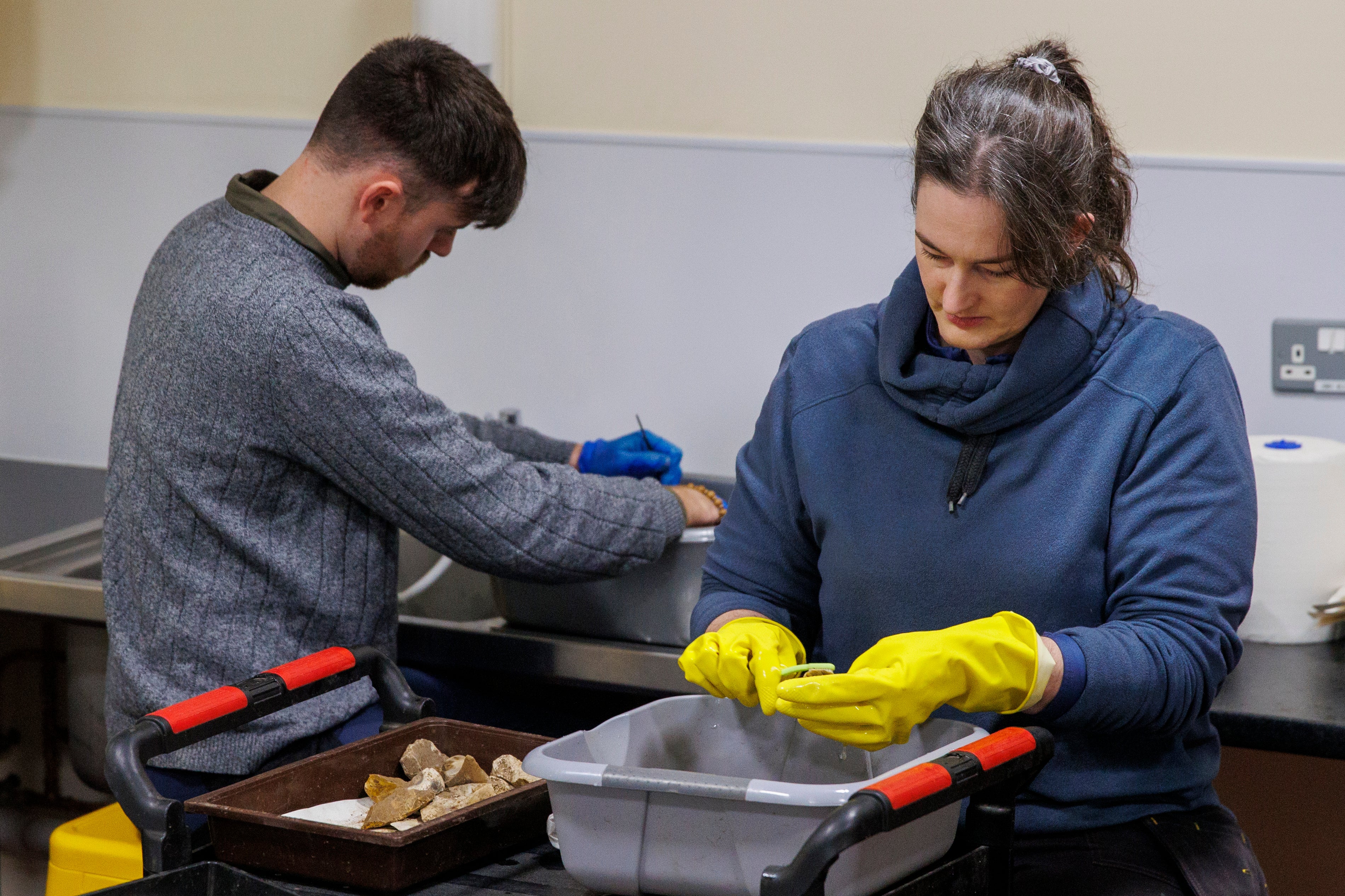 Staff at the archaeological store clean artefacts (Liam McBurney/PA).