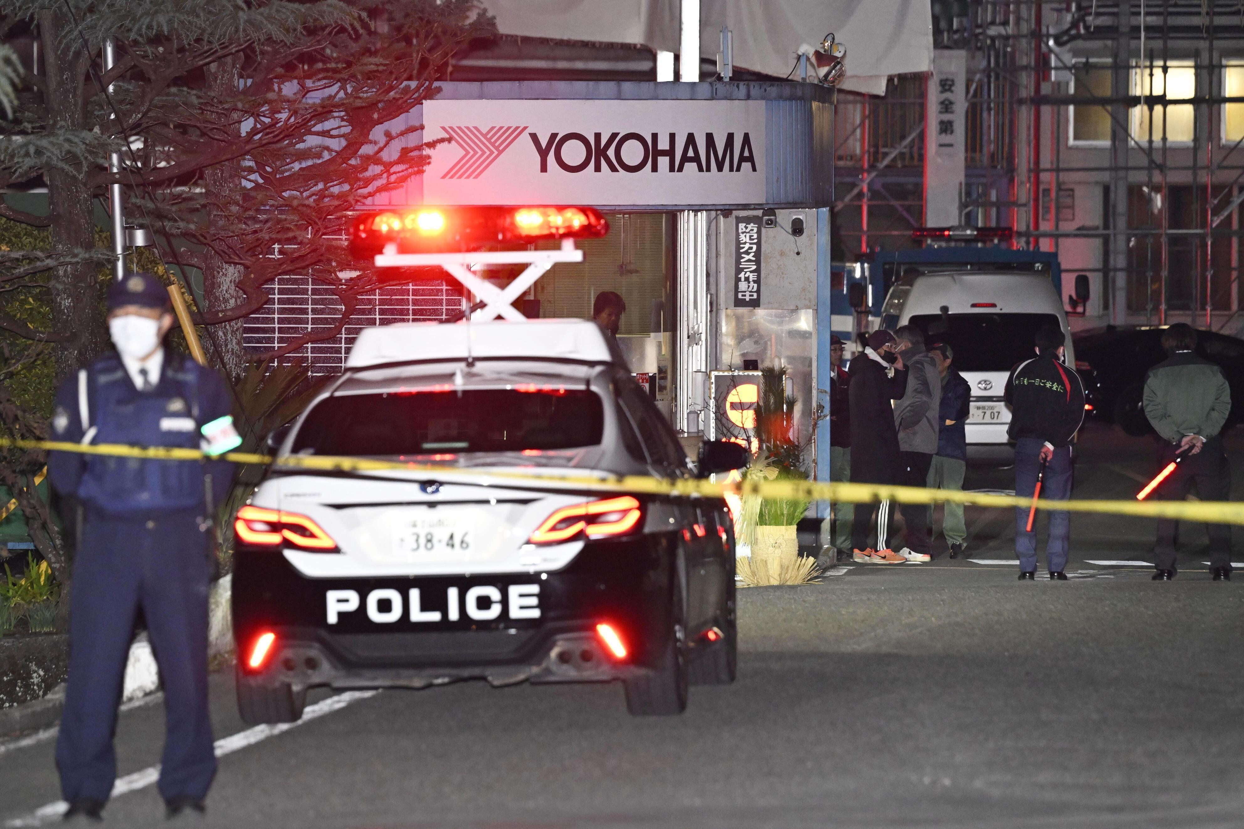 Police officers stand guard at the scene of a stabbing at the Yokohama Rubber Company in Mishima, west of Tokyo